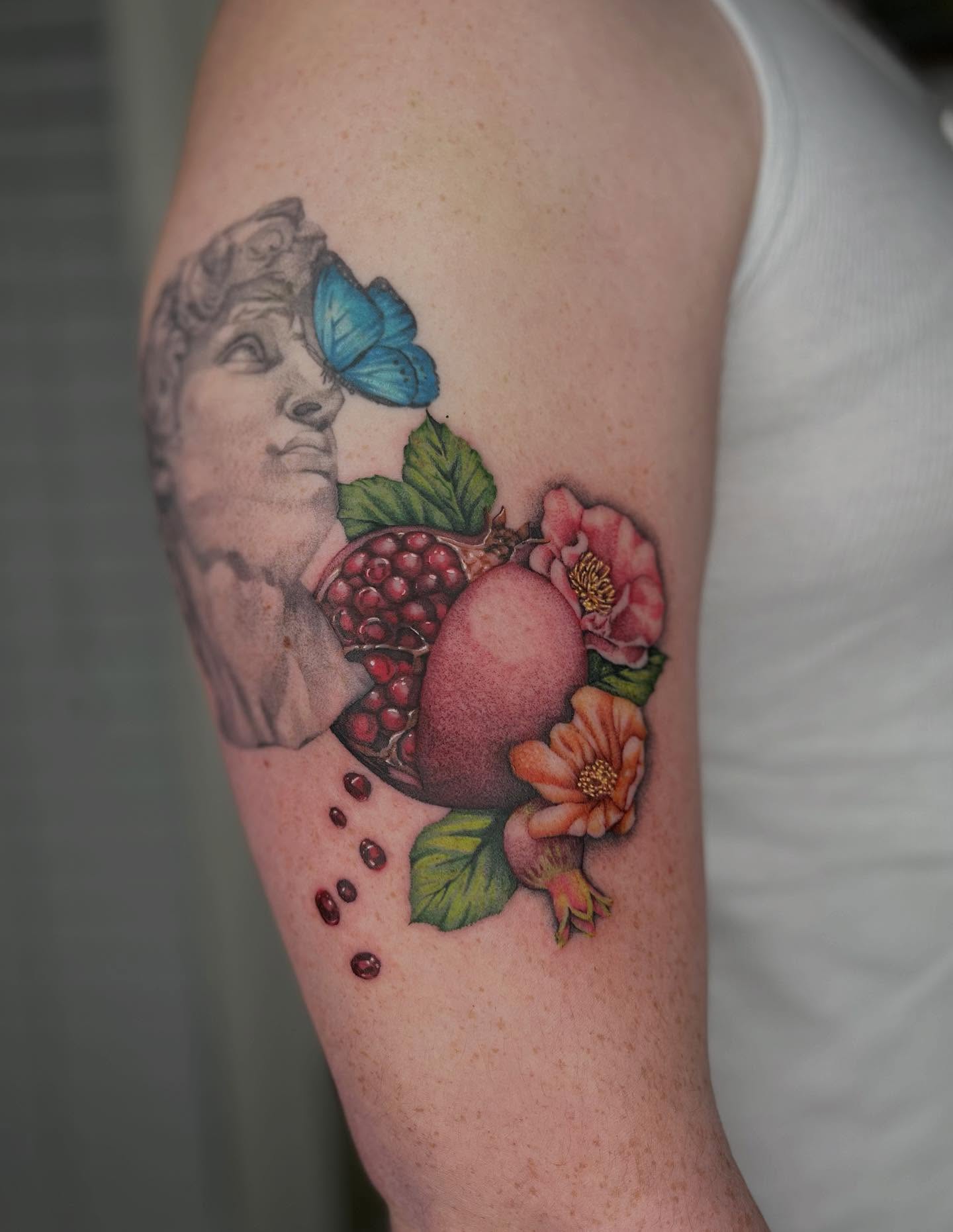 Pomegranate and flowers realism tattoo on the forearm by Ash F