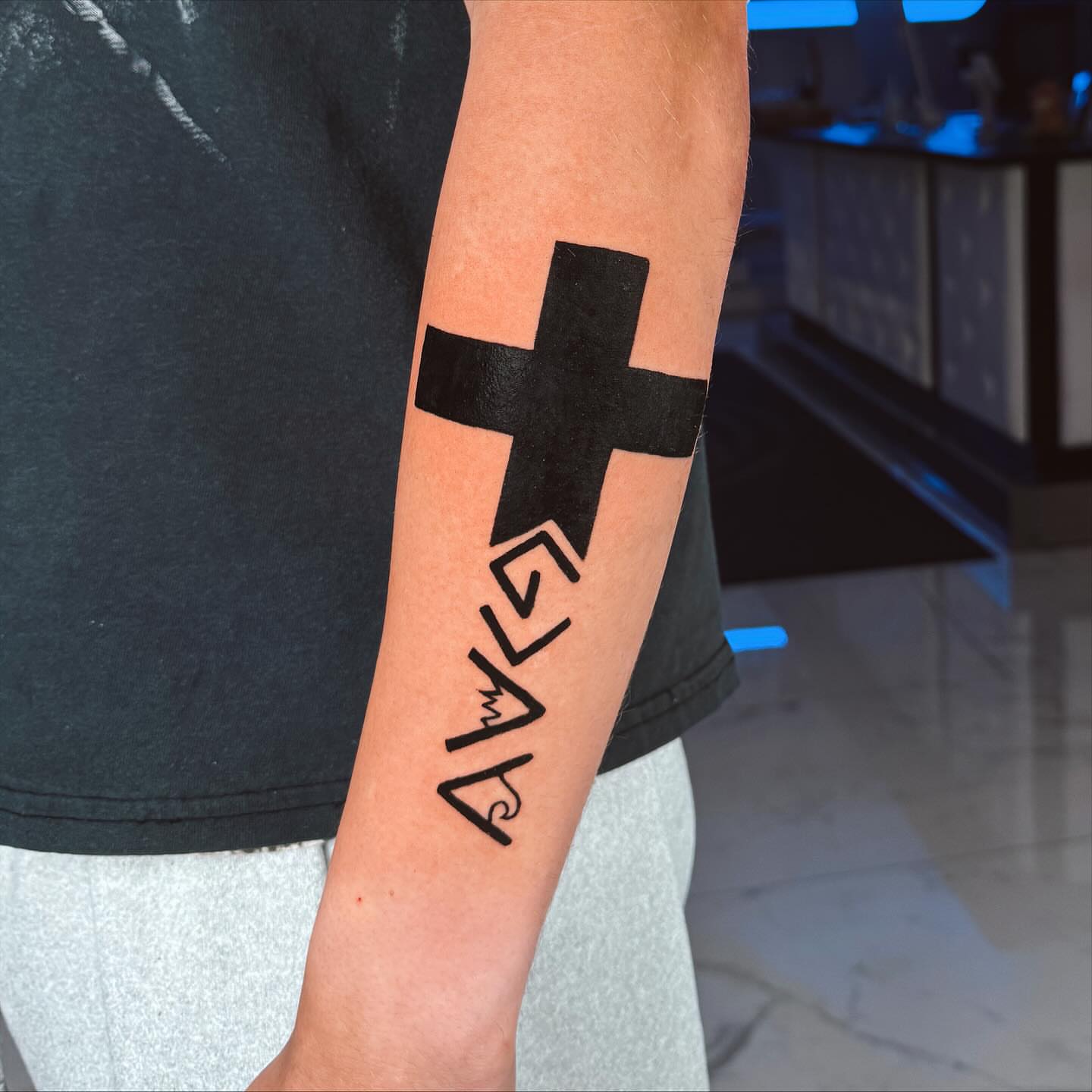 Cross with lettering black and grey tattoo on the forearm by Idalia Pulido