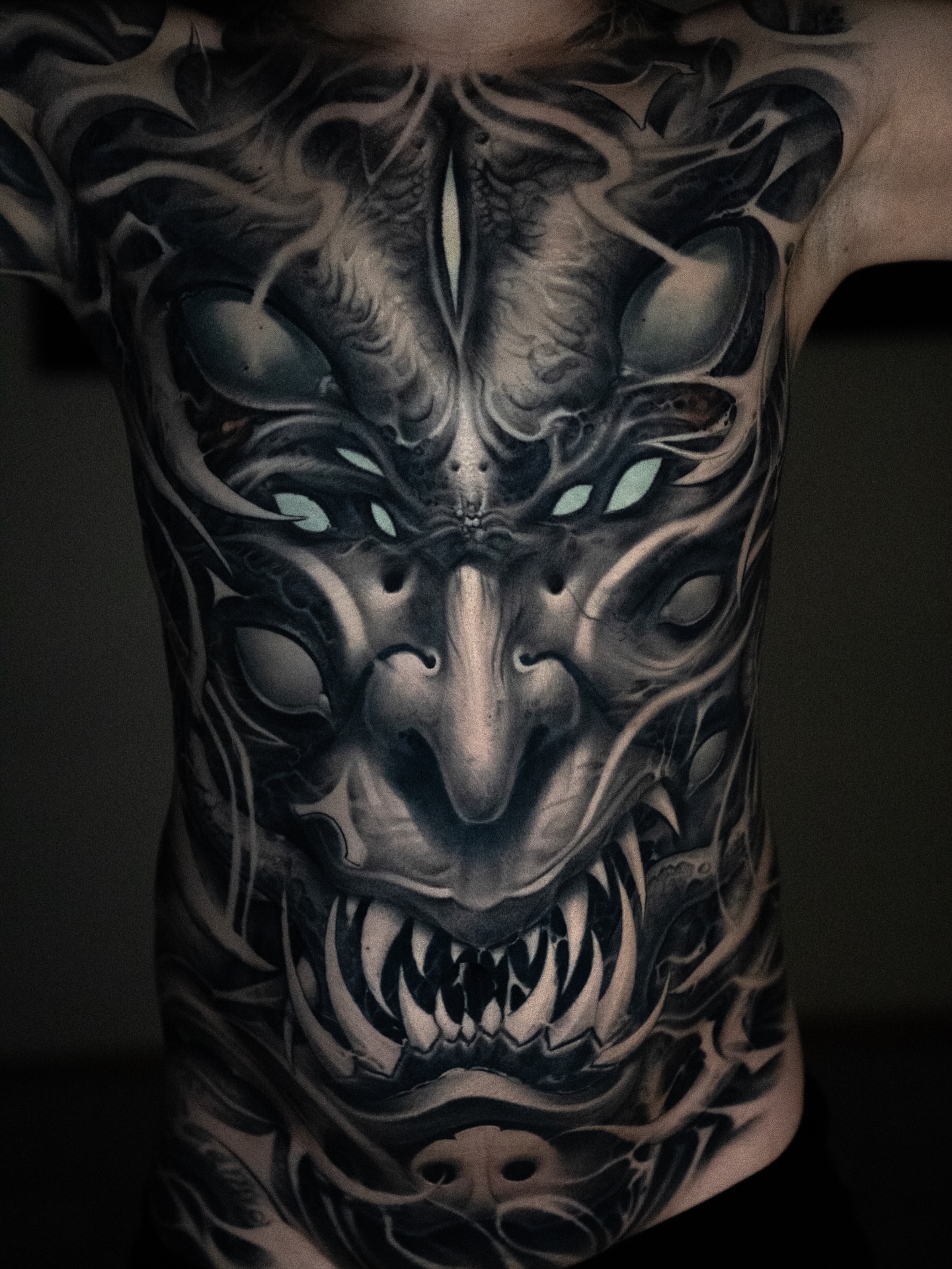 Demon face dark realism tattoo on the chest by Victor Portugal Tattoo