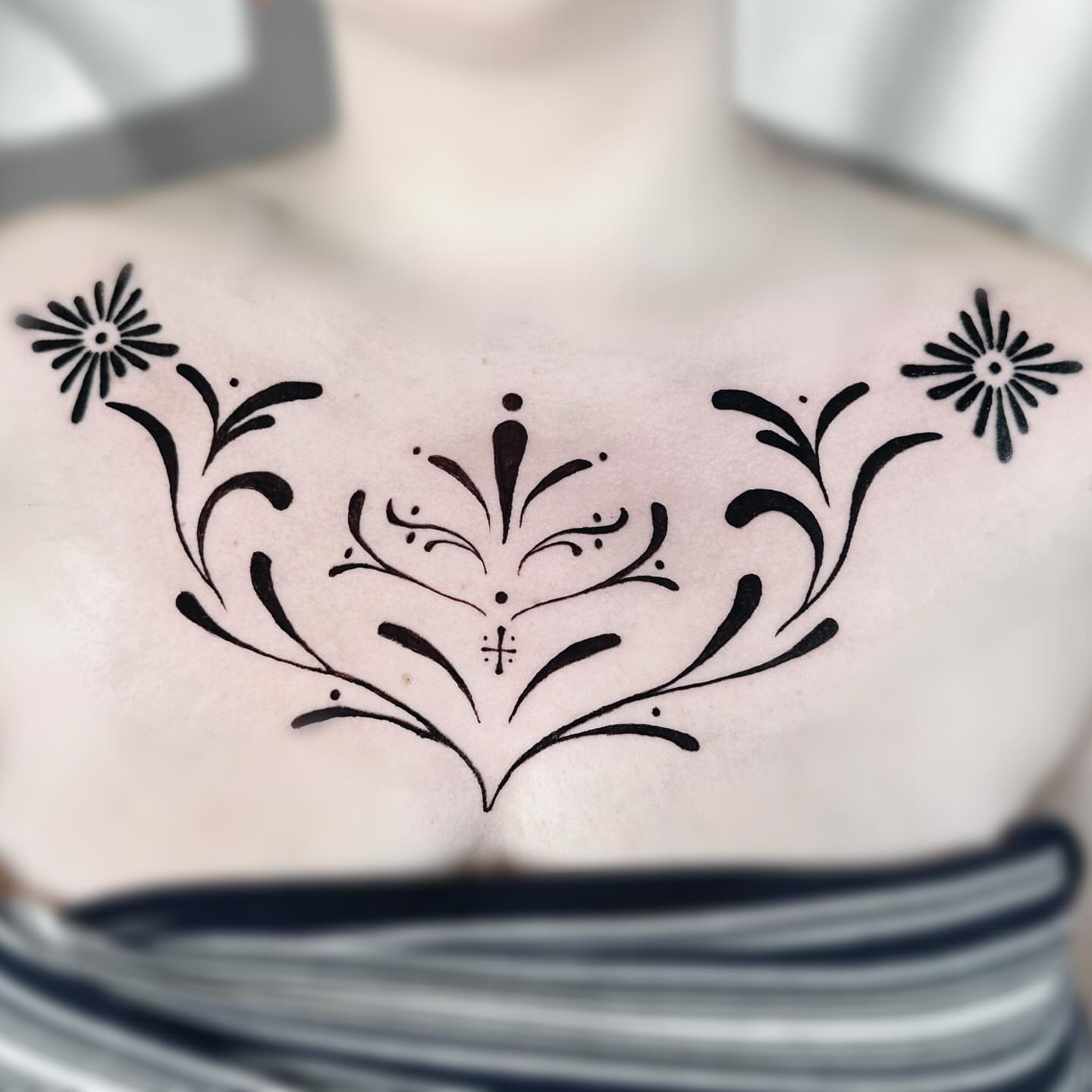 Floral design ornamental tattoo on the chest by Lex