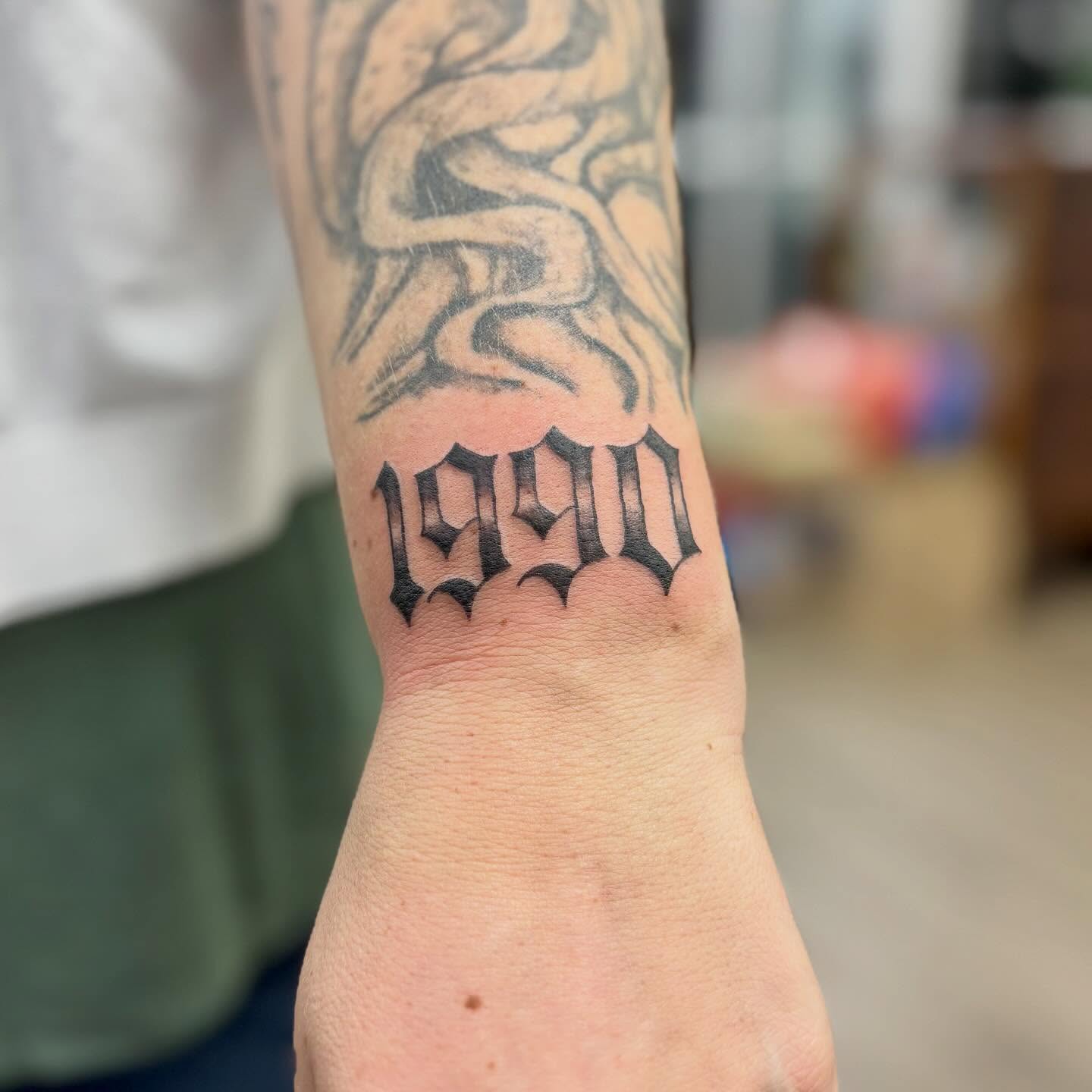1990 black and grey tattoo on the forearm by bradyn thornton: eco-tattoo artist