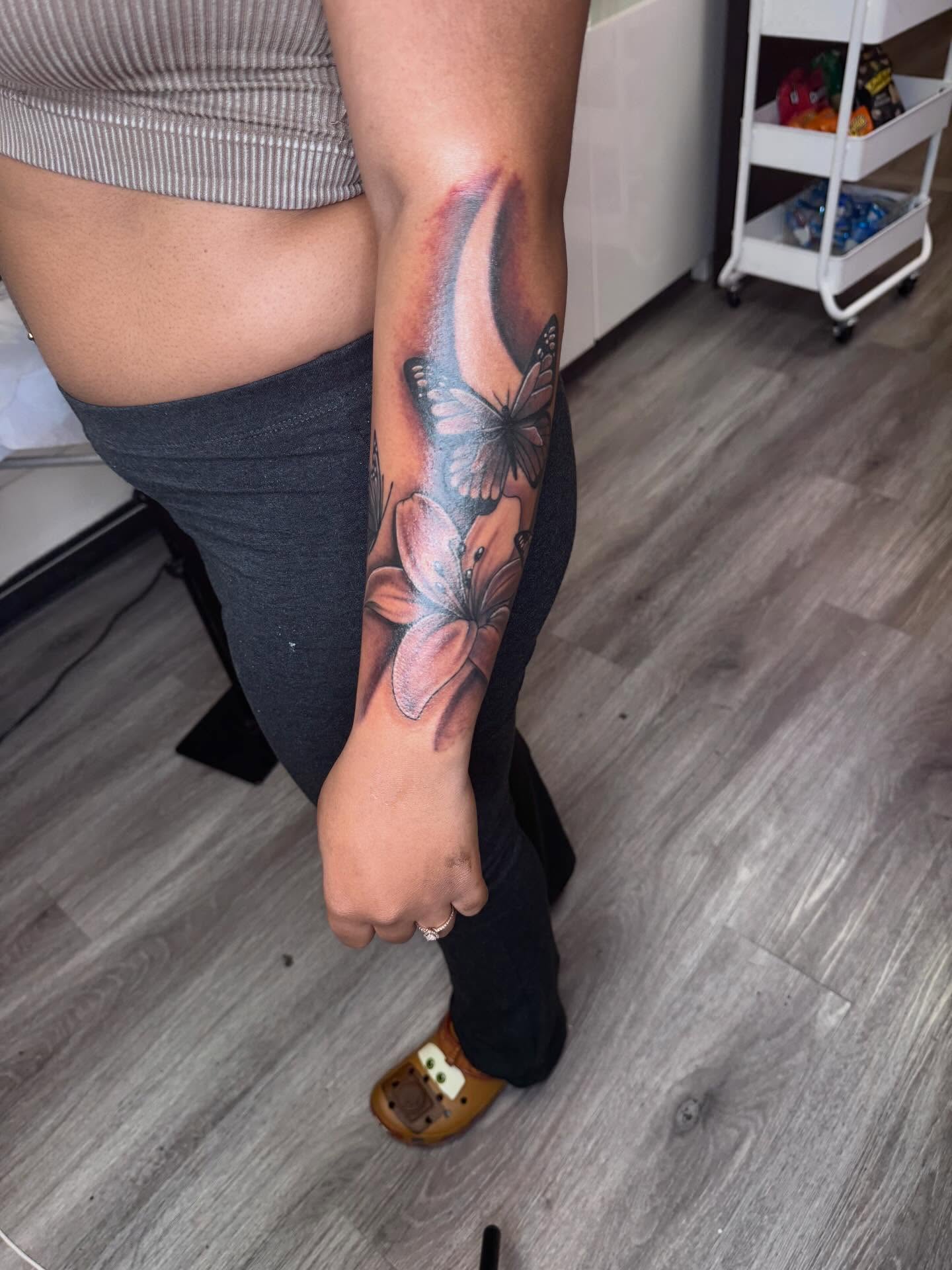 Flower and butterfly realism tattoo on the forearm by Sierra 🩷