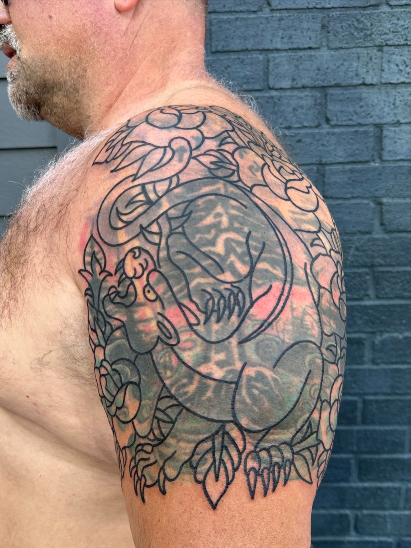 Tiger and floral black and grey tattoo on the shoulder by Chris Blanchard