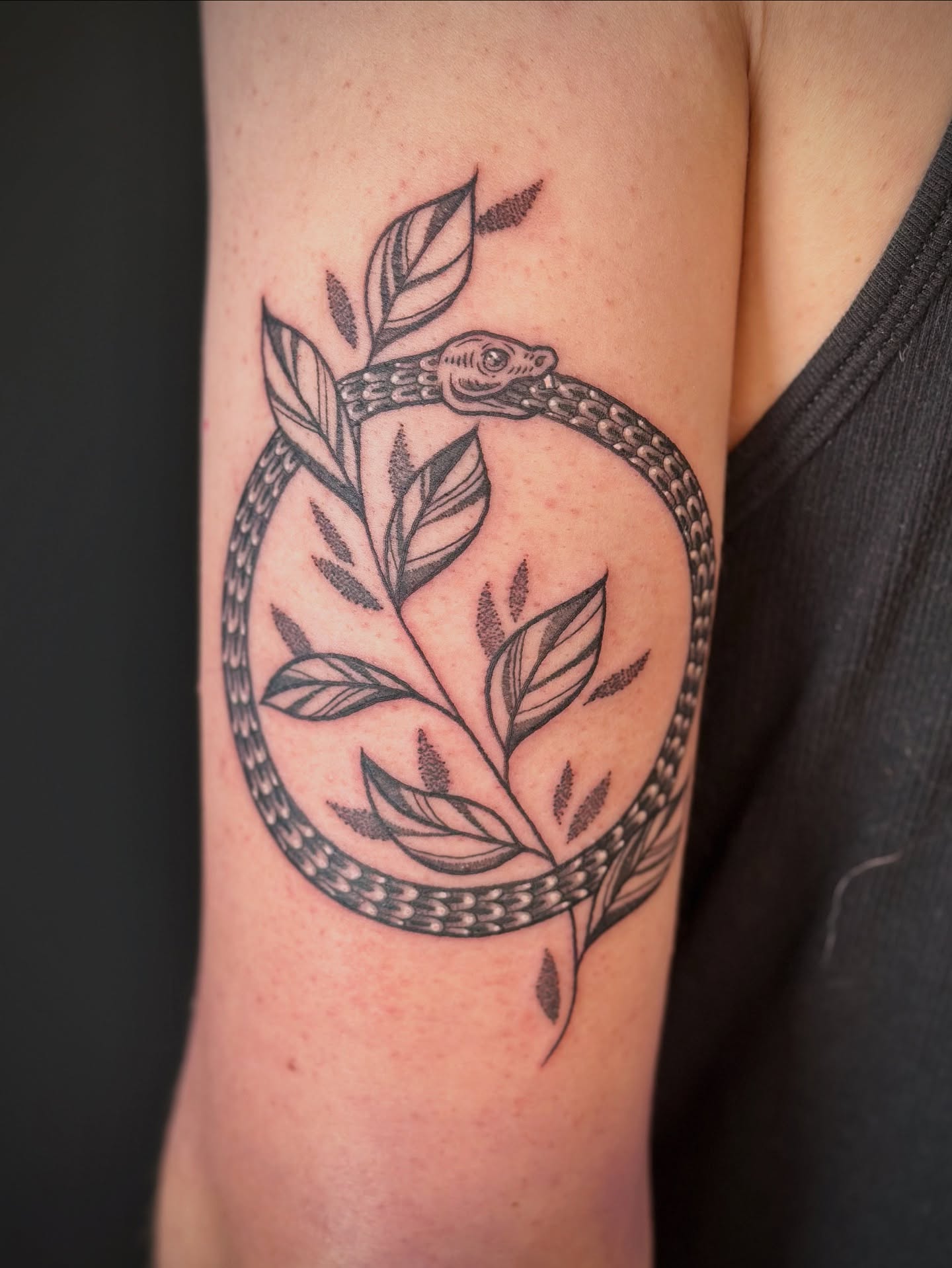 Snake and leaves black and grey tattoo on the forearm by Maddie Morrill