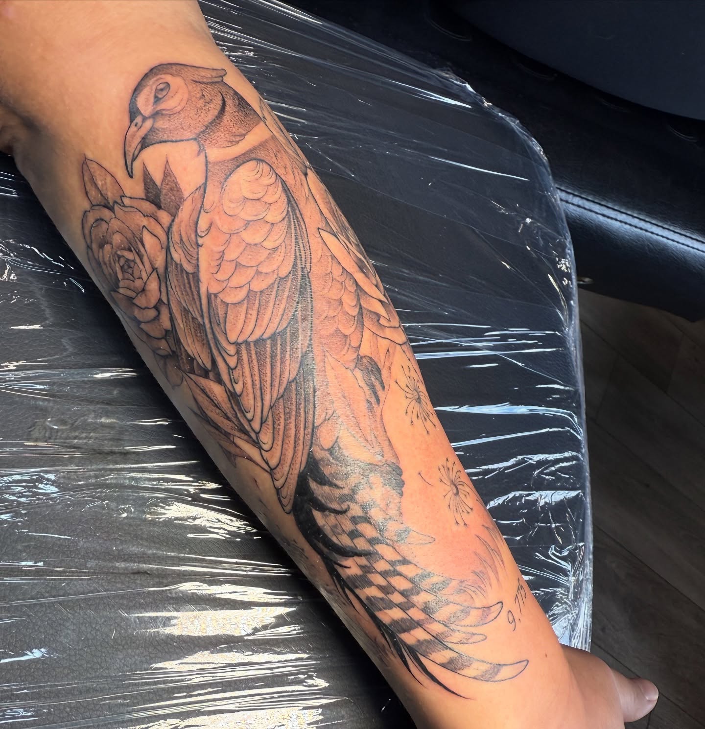 Bird and flowers black and grey tattoo on the forearm by Tayler Beetison