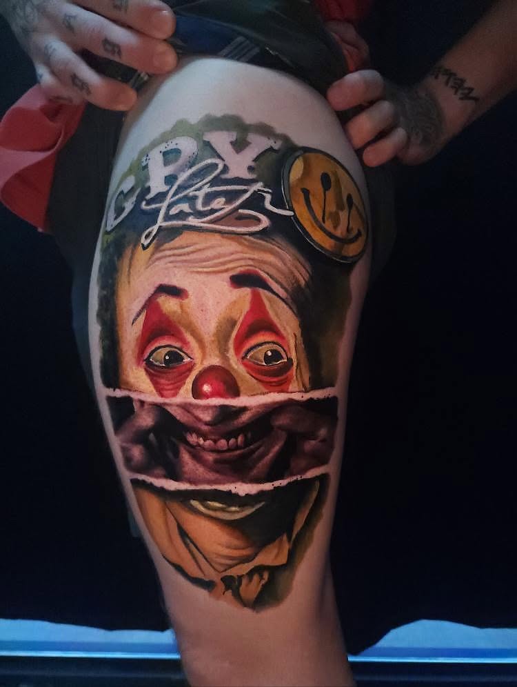 Clown face realism tattoo on the thigh by Tyler Cromwell