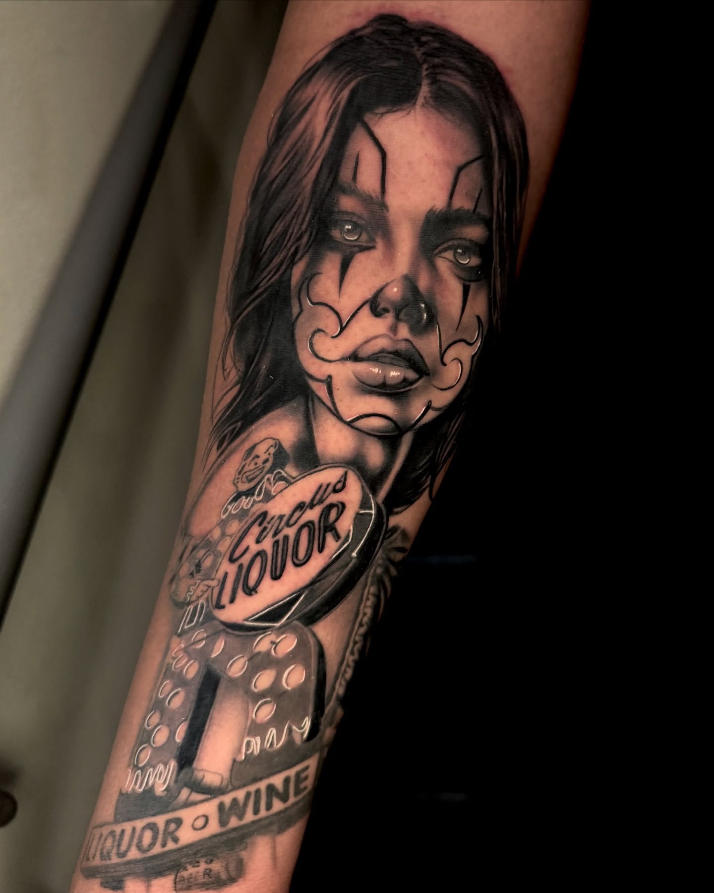 Woman with clown makeup realism tattoo on the forearm by Gabriel Quintana “Q”