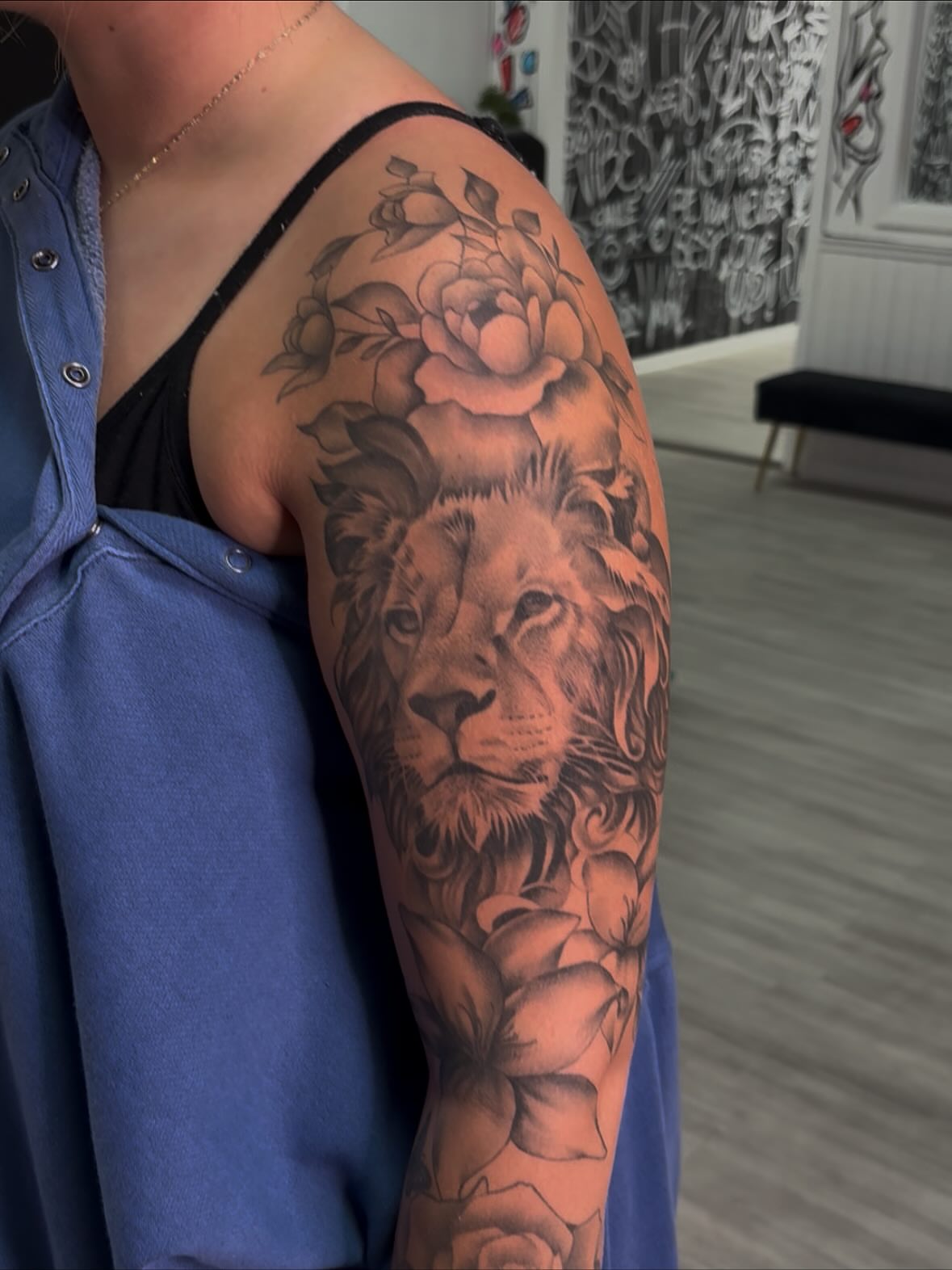 Lion and roses realism tattoo on the upper arm by Savannah Tattoo Artist
