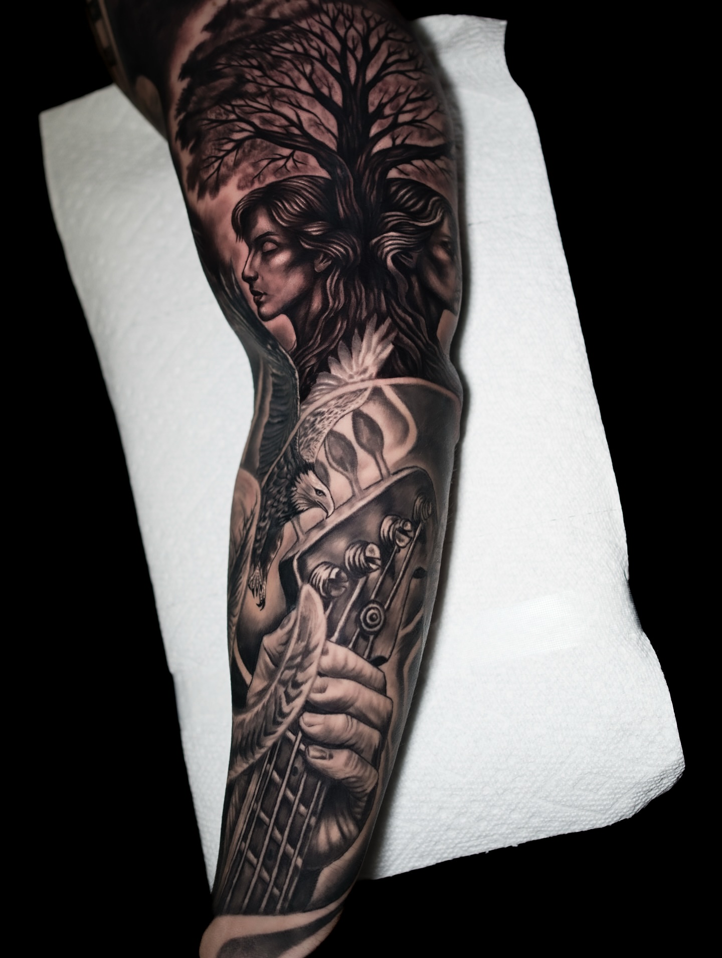 Bass player with tree realism tattoo on the forearm by Juan David Arias