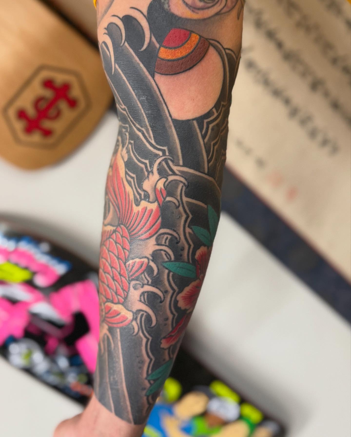 Koi fish and waves American traditional tattoo on the forearm by Jason Eisenberg