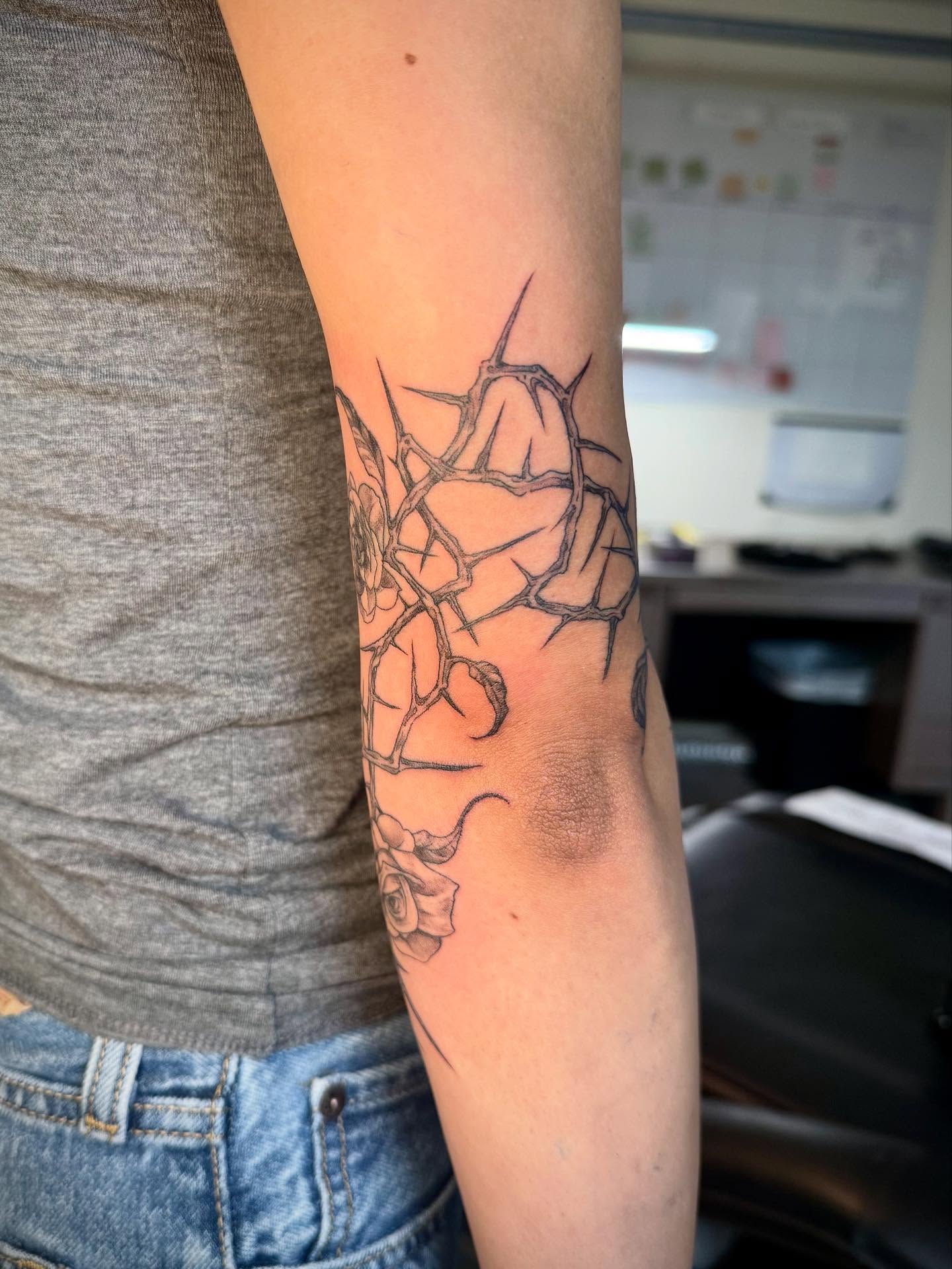 Thorn and rose black and grey tattoo on the forearm by Quin Walker