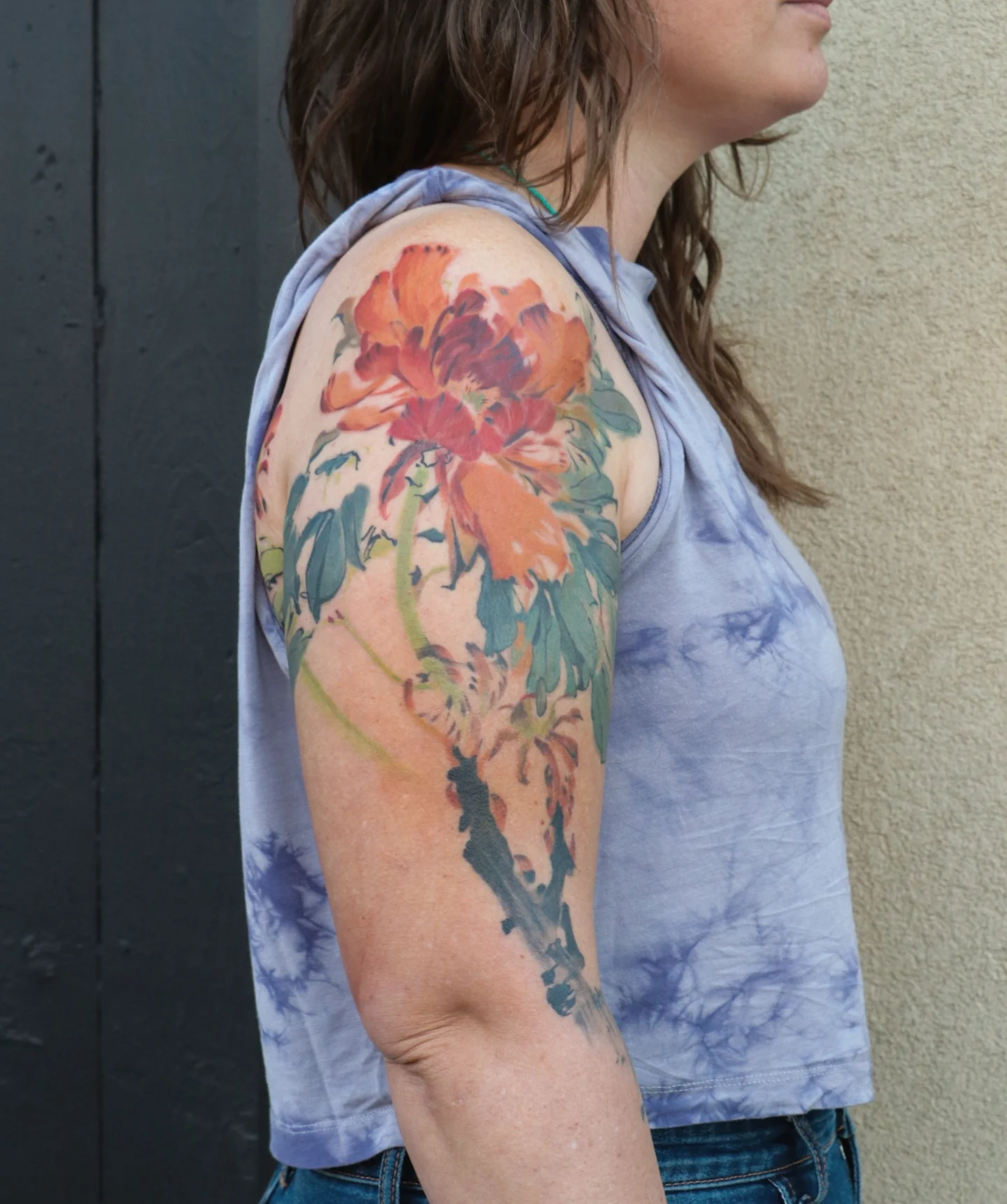 Peony watercolor tattoo on the upper arm by Jhenn