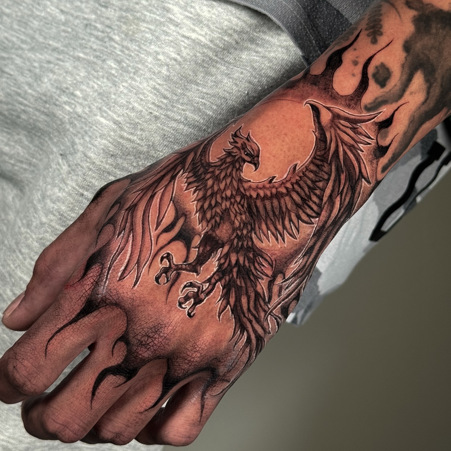 Phoenix black and grey tattoo on the hand by Brisia Cisneros