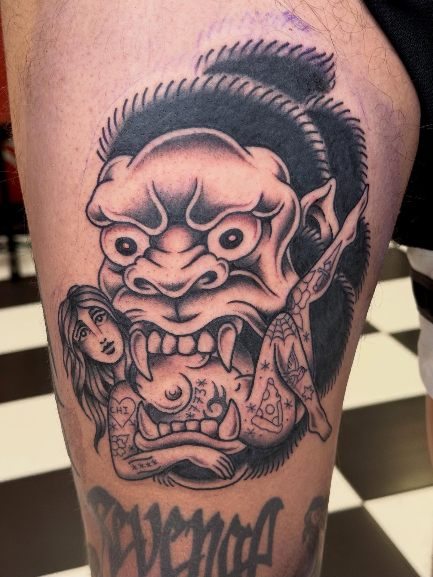 Demon head with woman American traditional tattoo on the thigh by Emma Eaton