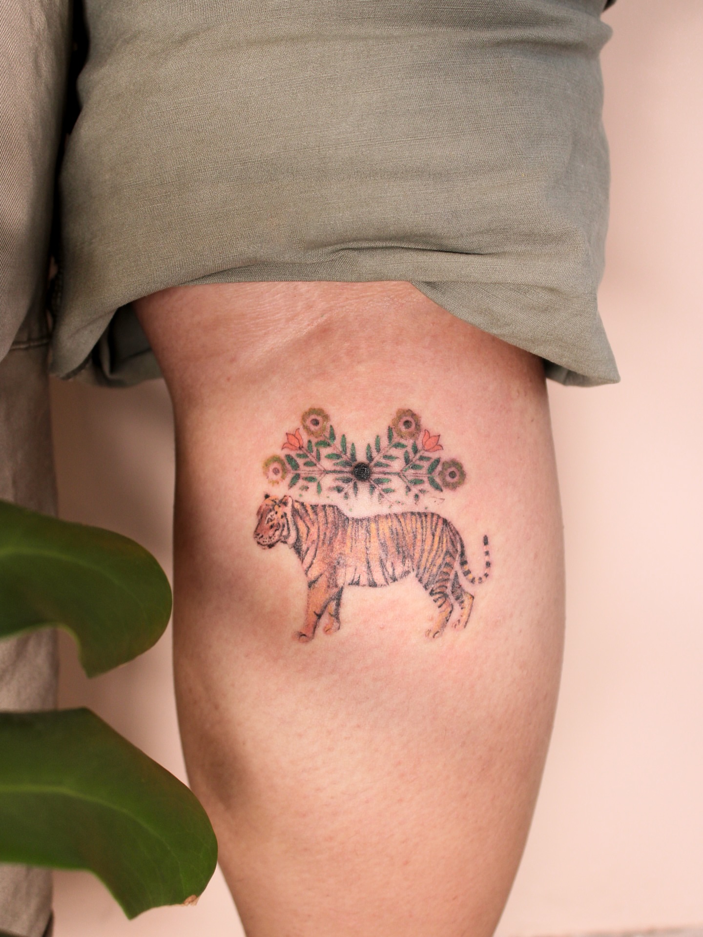 Tiger with floral arrangement new school tattoo on the thigh by Micah Light (color micro realism, Los Angeles, California