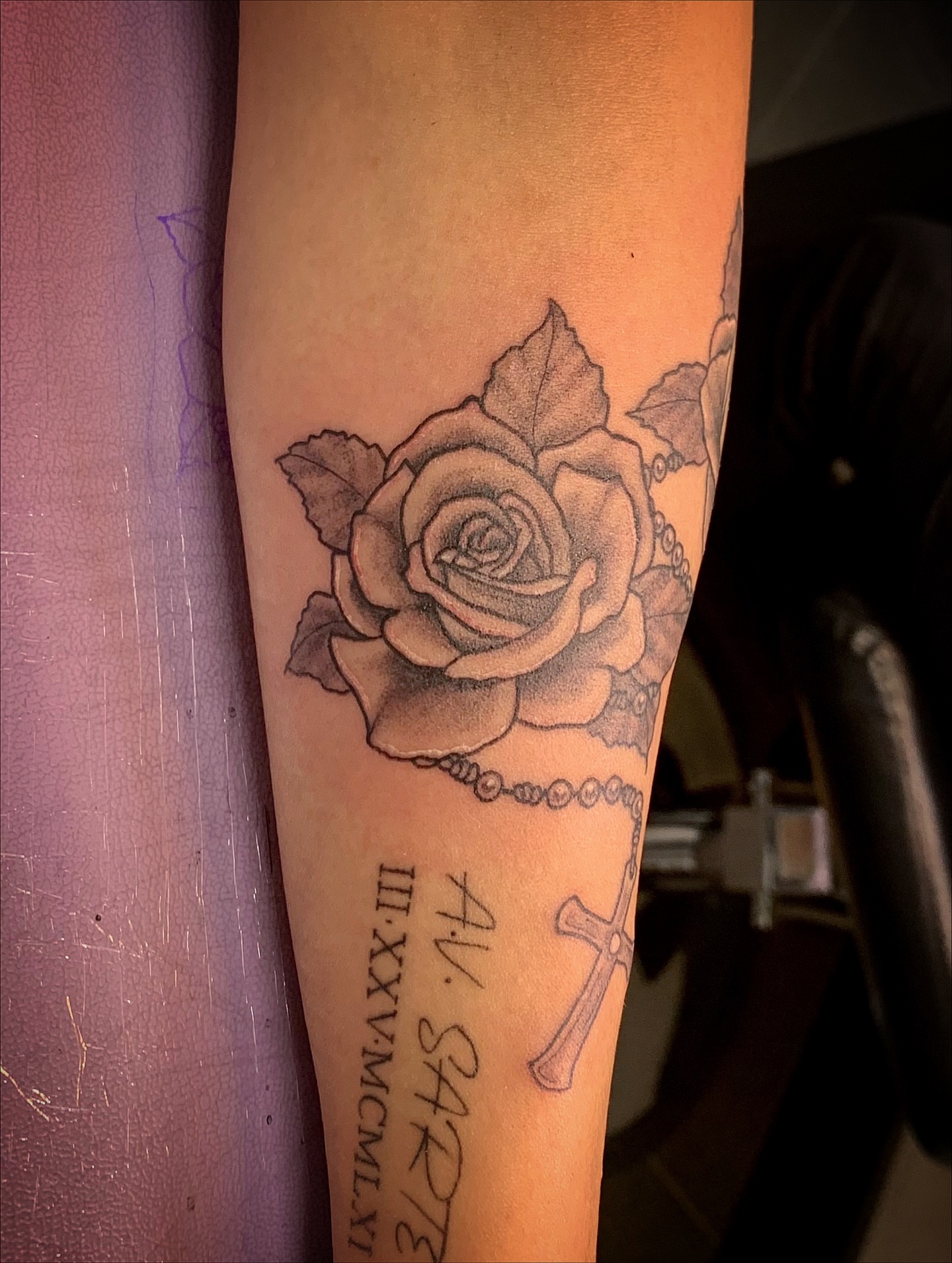 Rose and rosary black and grey tattoo on the forearm by Laura