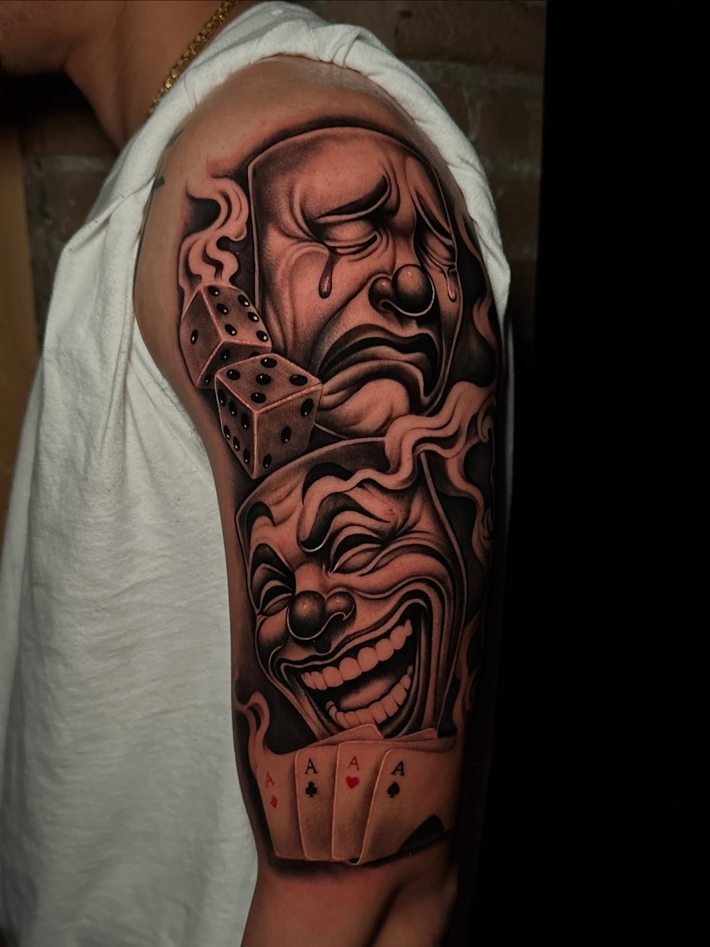 Joker faces and playing cards realism tattoo on the forearm by Miguel Saucedo
