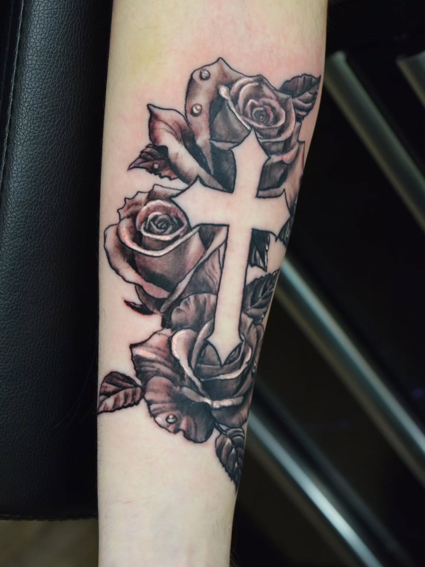 Cross with roses black and grey tattoo on the forearm by Bruce Riehl