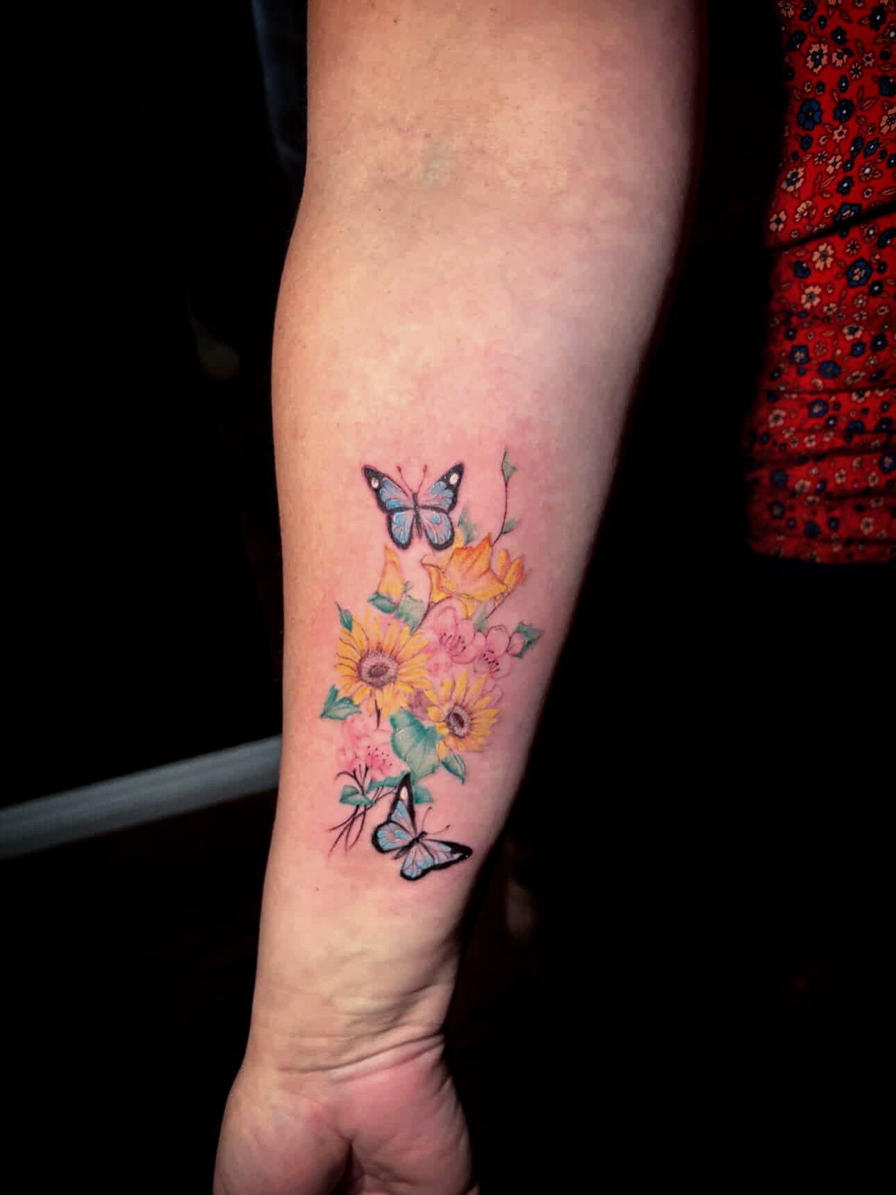Butterfly and flowers watercolor tattoo on the forearm by Cultura