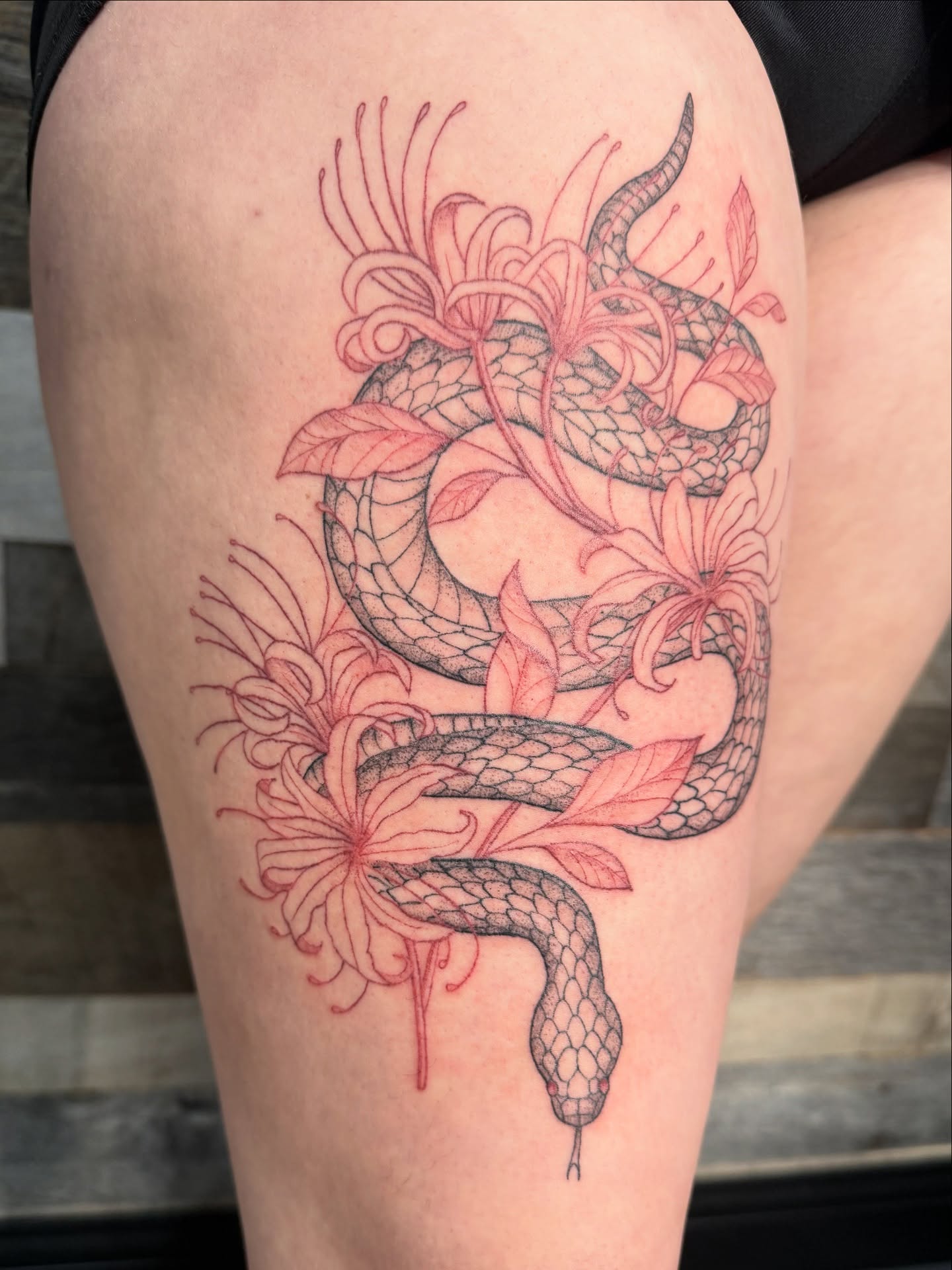 Snake and flowers new school tattoo on the thigh by Tina Petrullo, West Chester Township, Butler County, Ohio