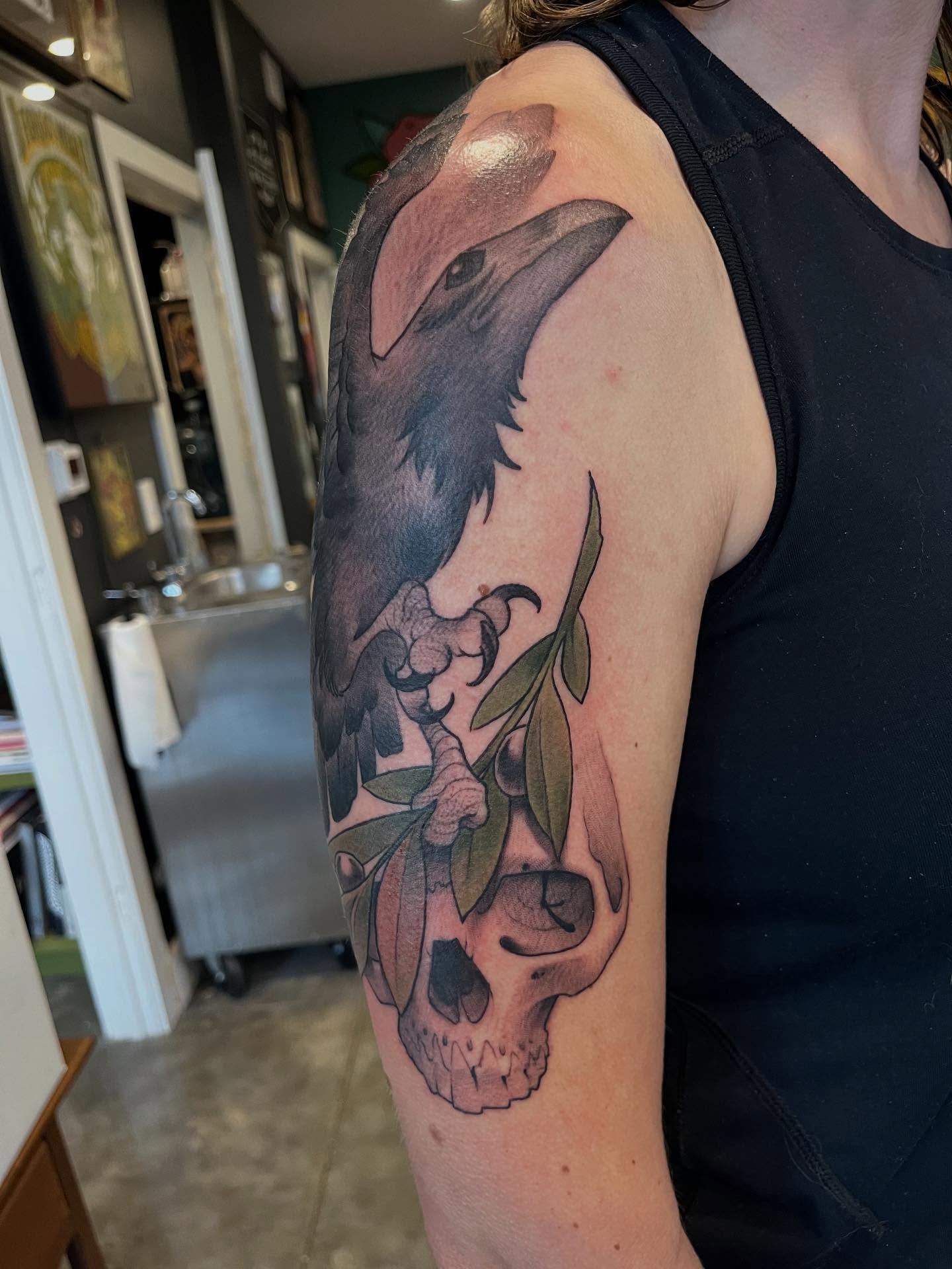 Crow and skull realism tattoo on the upper arm by Ian White
