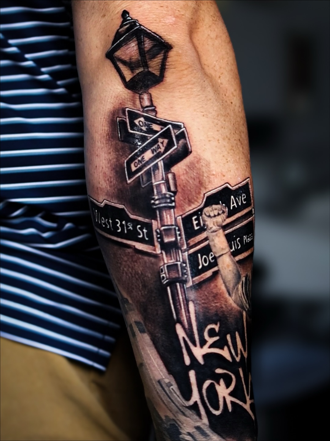 Street signs and lamp post realism tattoo on the forearm by Lauren klose, Fort Myers, Florida