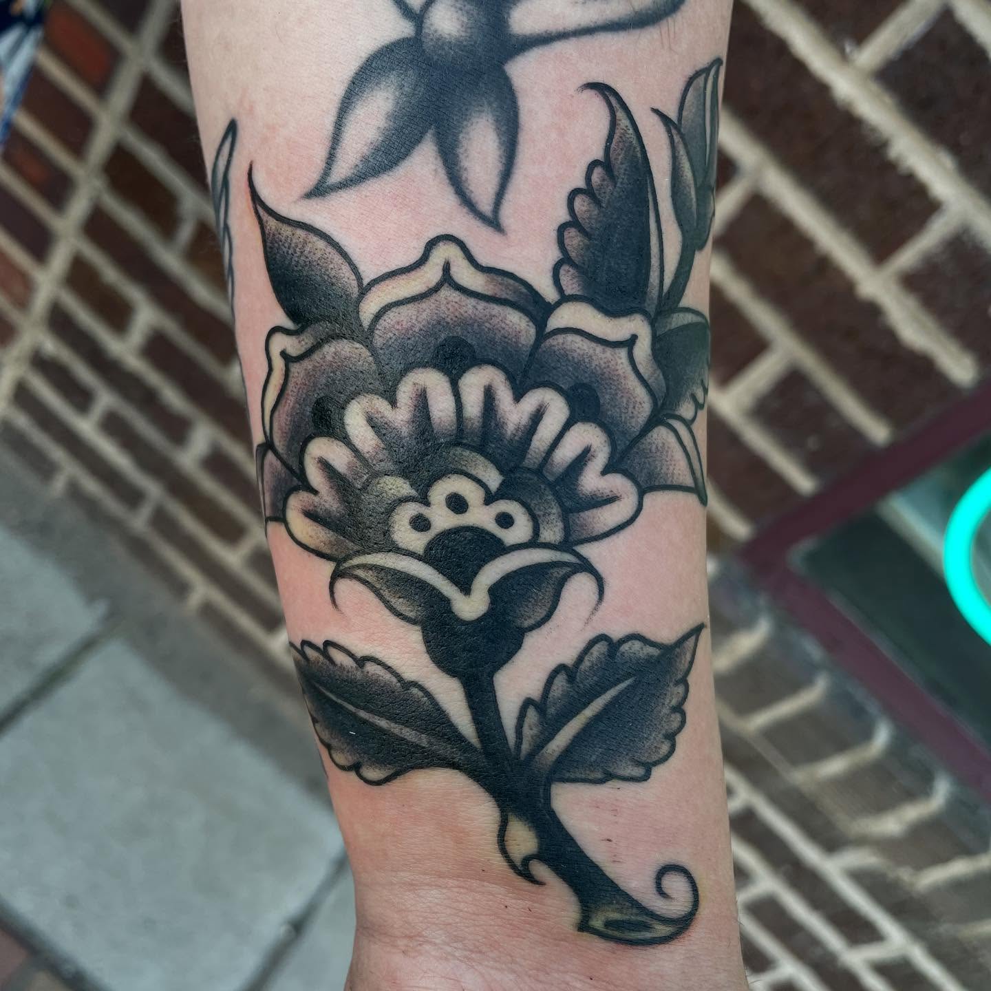Flower black and grey tattoo on the forearm by Haley McMahon