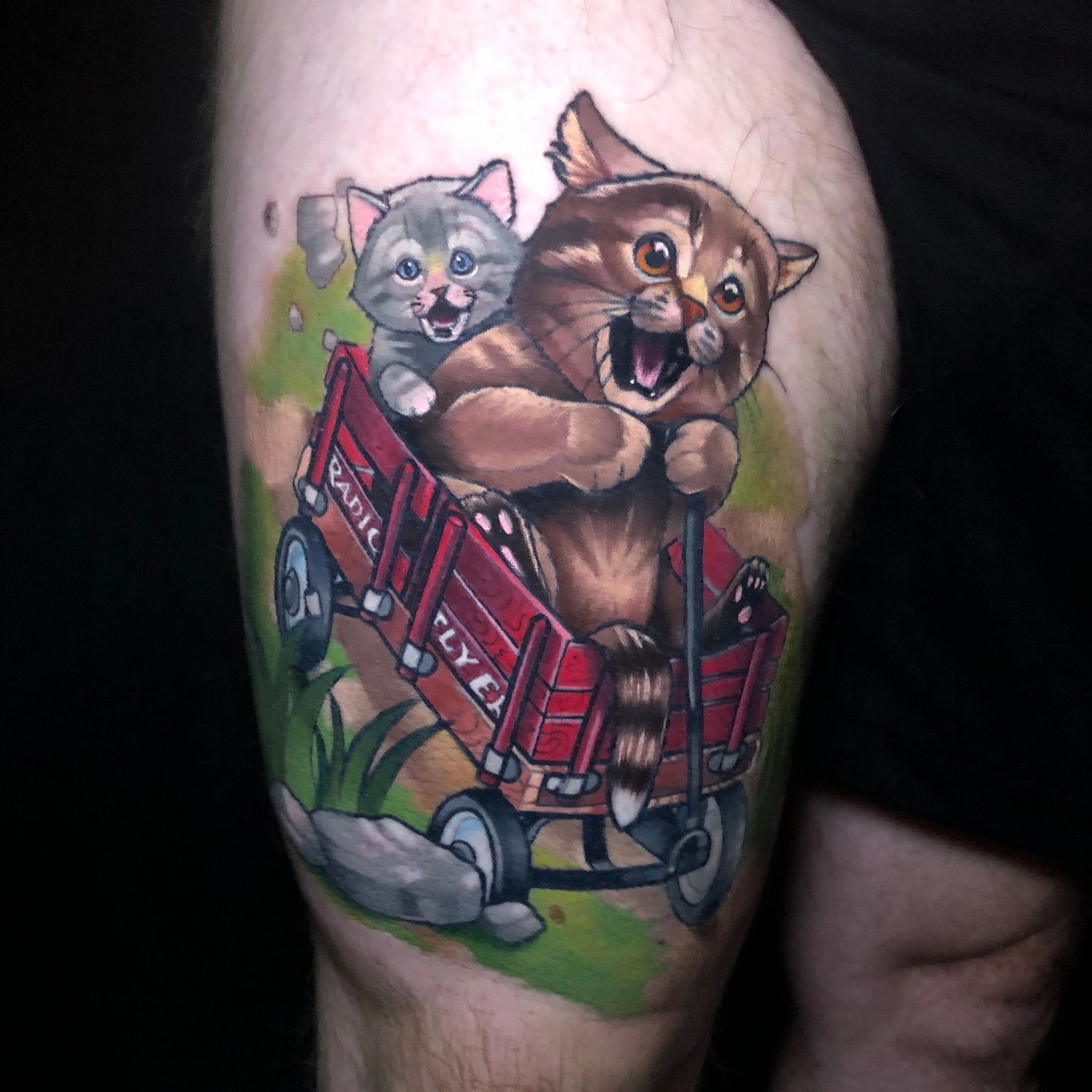 Cat pulling wagon realism tattoo on the thigh by Emily Walker