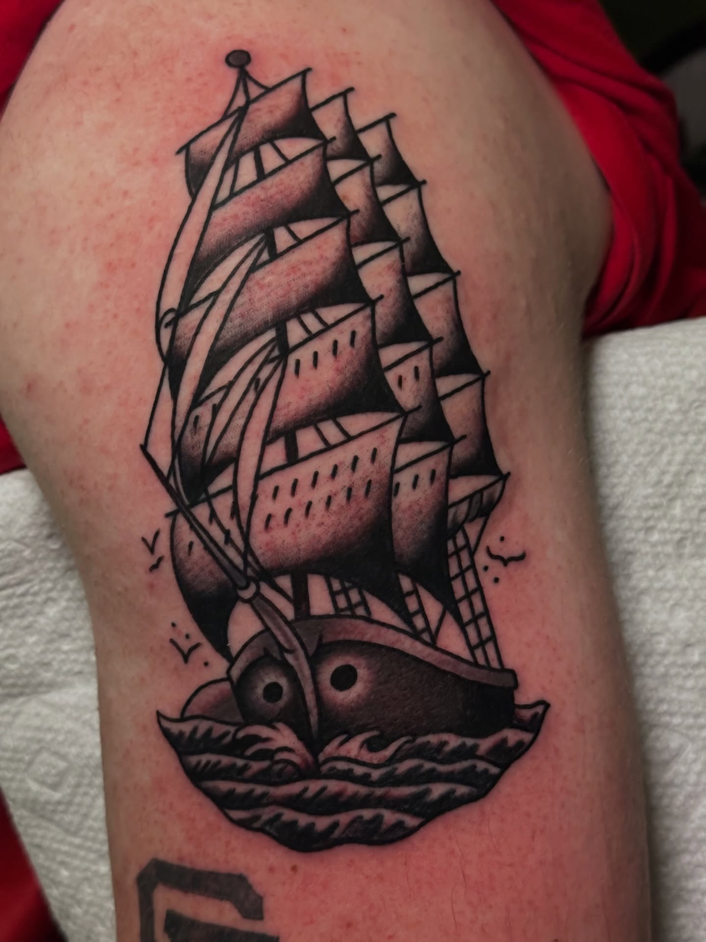 Sailboat American traditional tattoo on the thigh by Brandon Bear