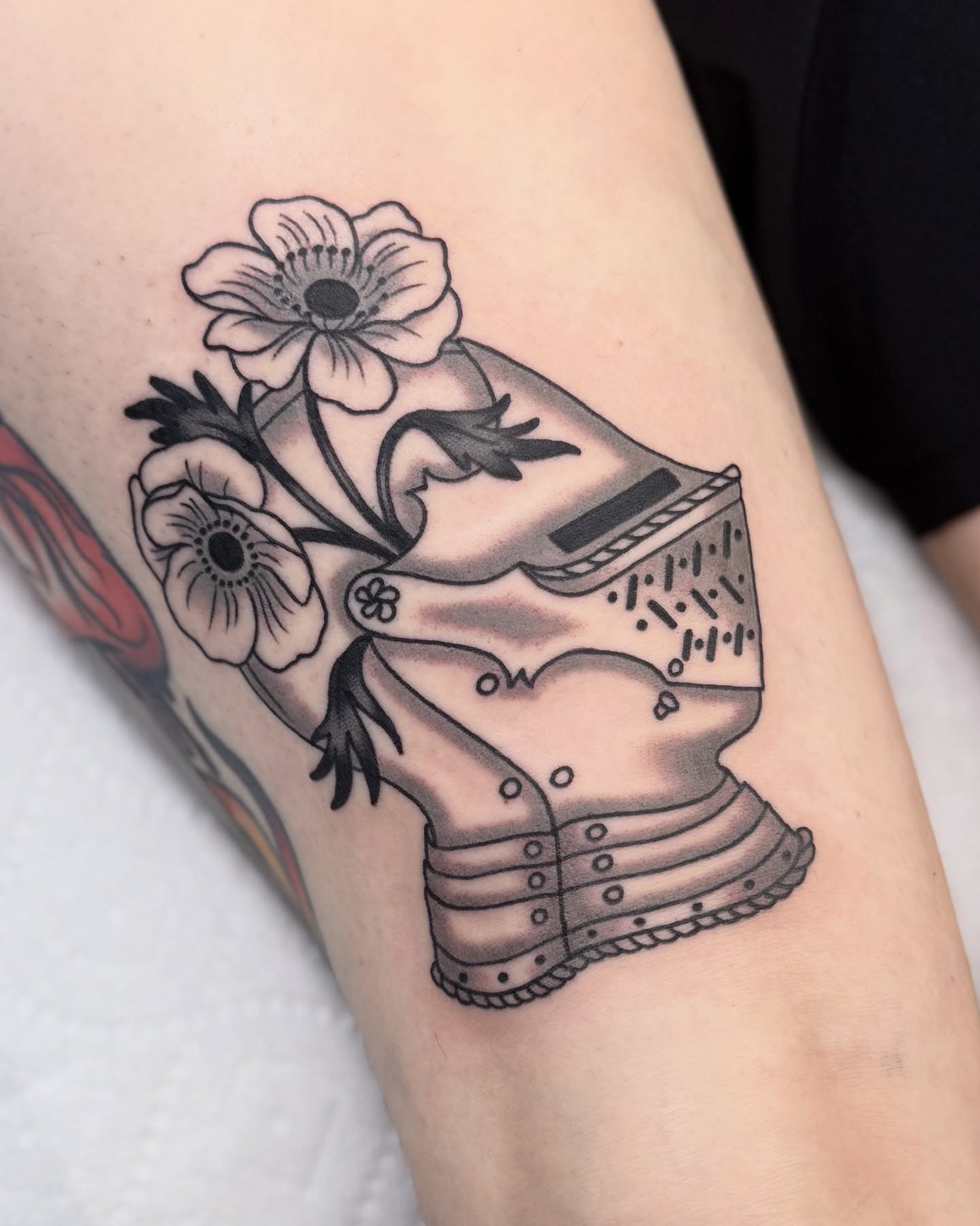 Boot and flowers black and grey tattoo on the forearm by Nia (Knee-uhh) 🦷