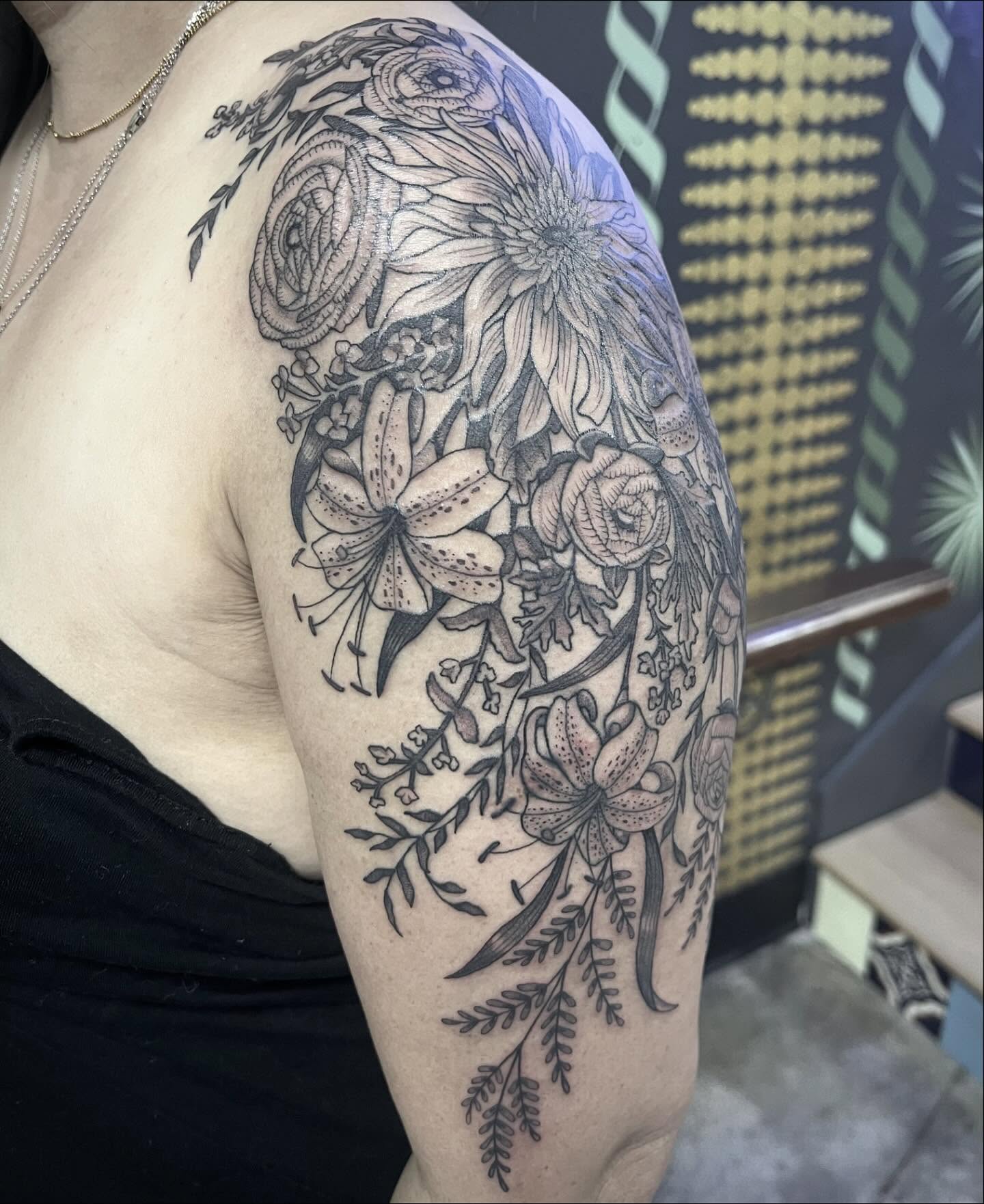 Floral arrangement black and grey tattoo on the upper arm by Natalie Phillips, Oakland, California