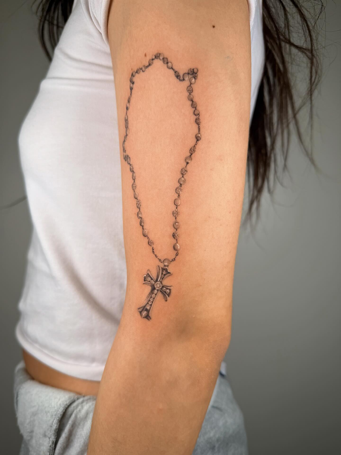 Rosary black and grey tattoo on the forearm by Nate Weaver