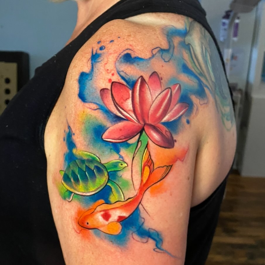 Lotus flower watercolor tattoo on the shoulder by High Vibrations