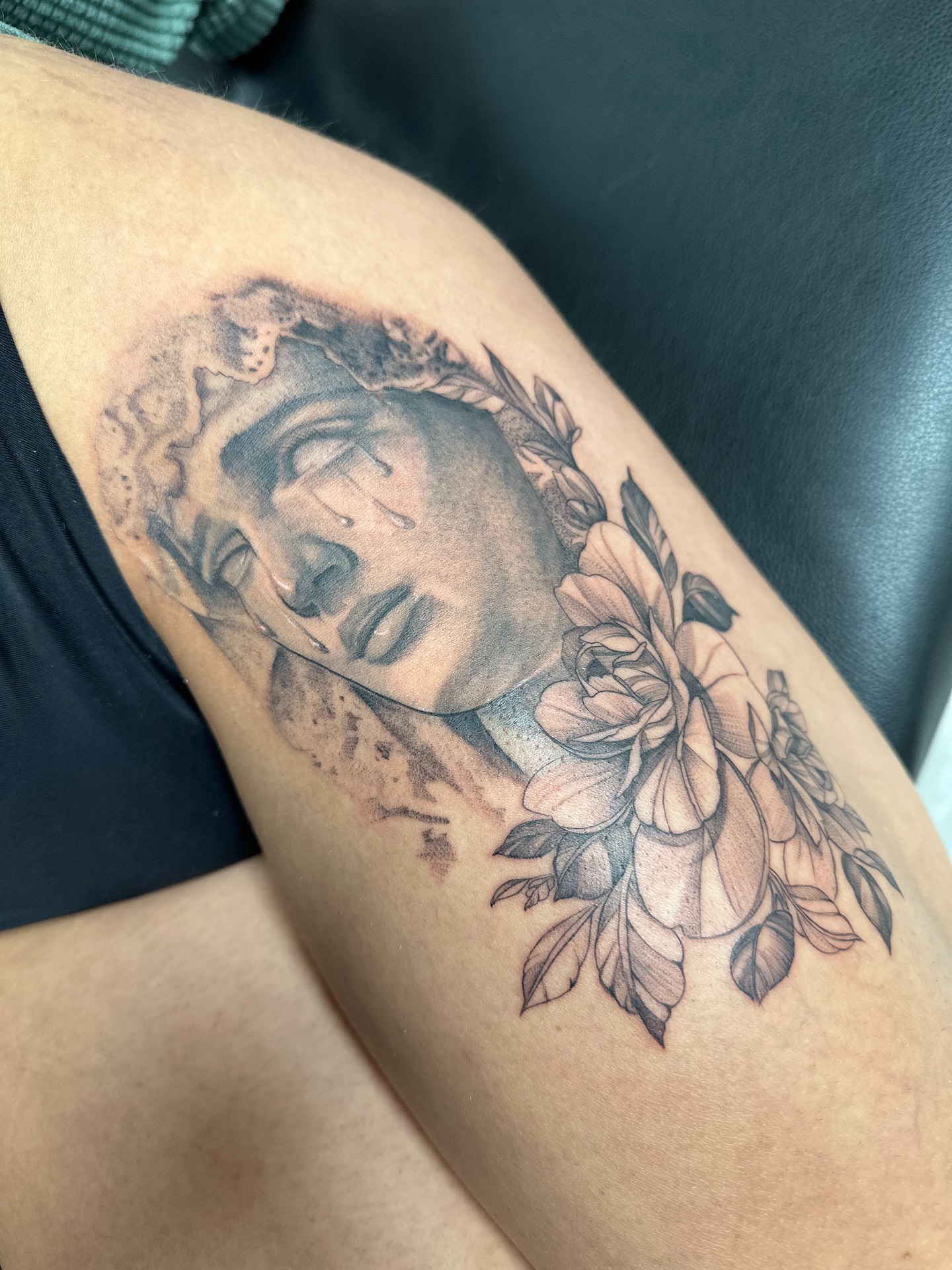 Sleeping face with flowers realism tattoo on the thigh by Antonio