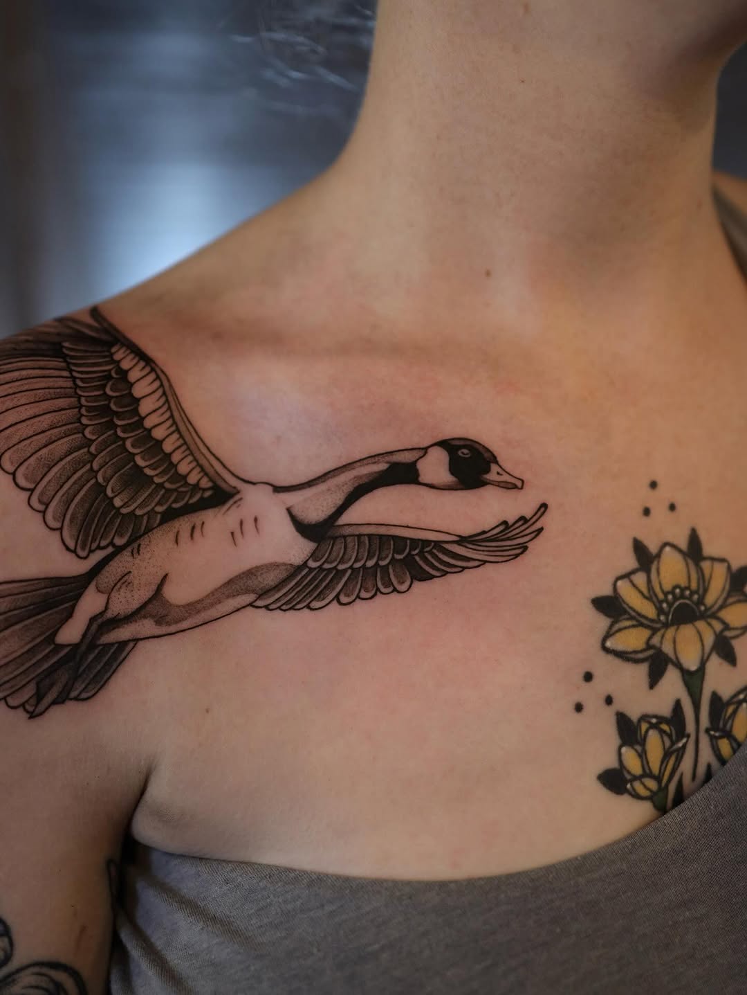 Flying goose and flowers fine line tattoo on the chest by morgan purcey
