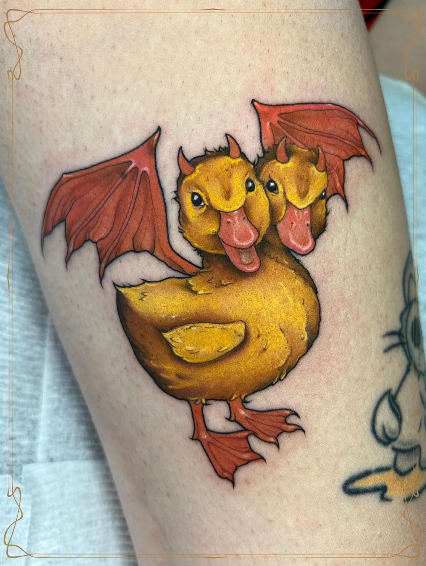 Duckling with wings new school tattoo on the thigh by Severin Black