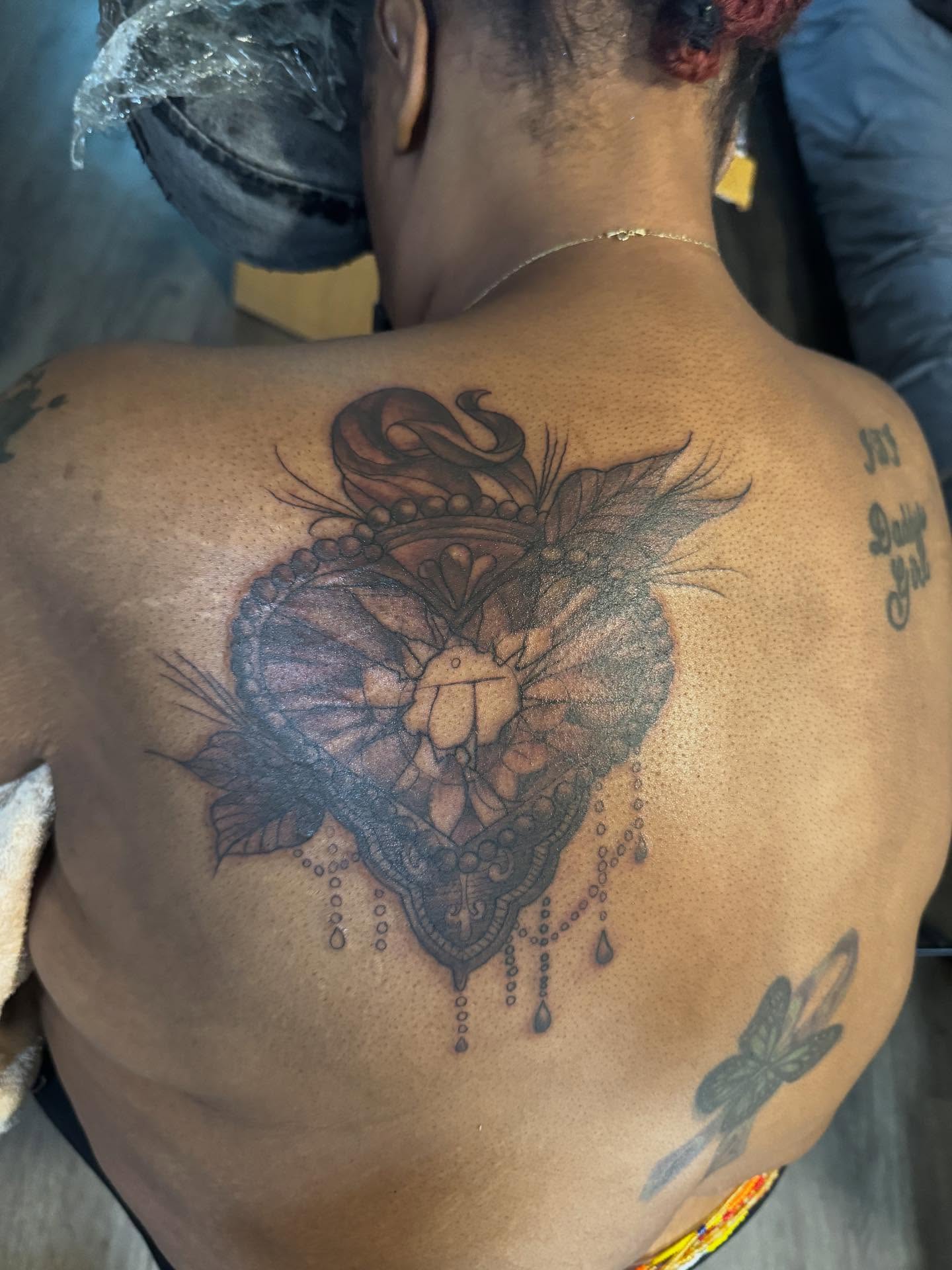 Heart with floral elements ornamental tattoo on the back by Gabe