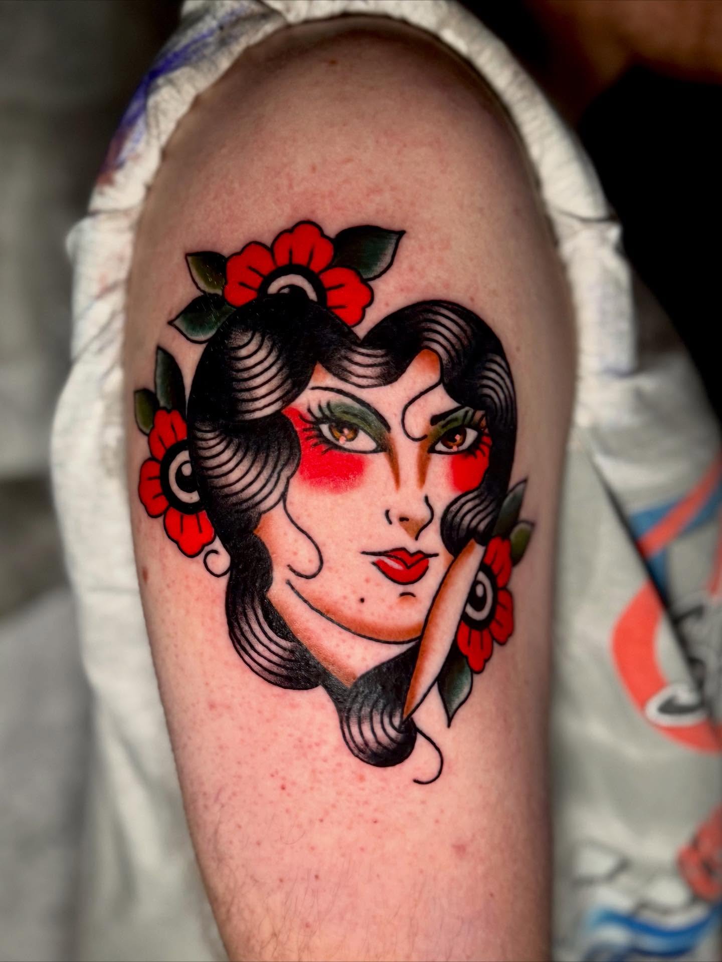 Woman with flowers American traditional tattoo on the forearm by Seth Walker