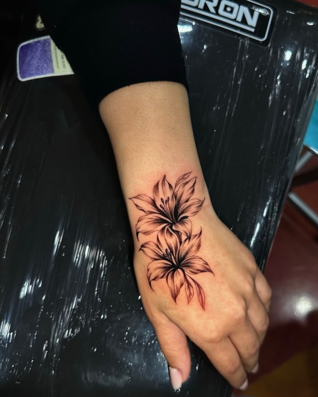 Flowers black and grey tattoo on the hand by Emma Sferdian🇷🇴