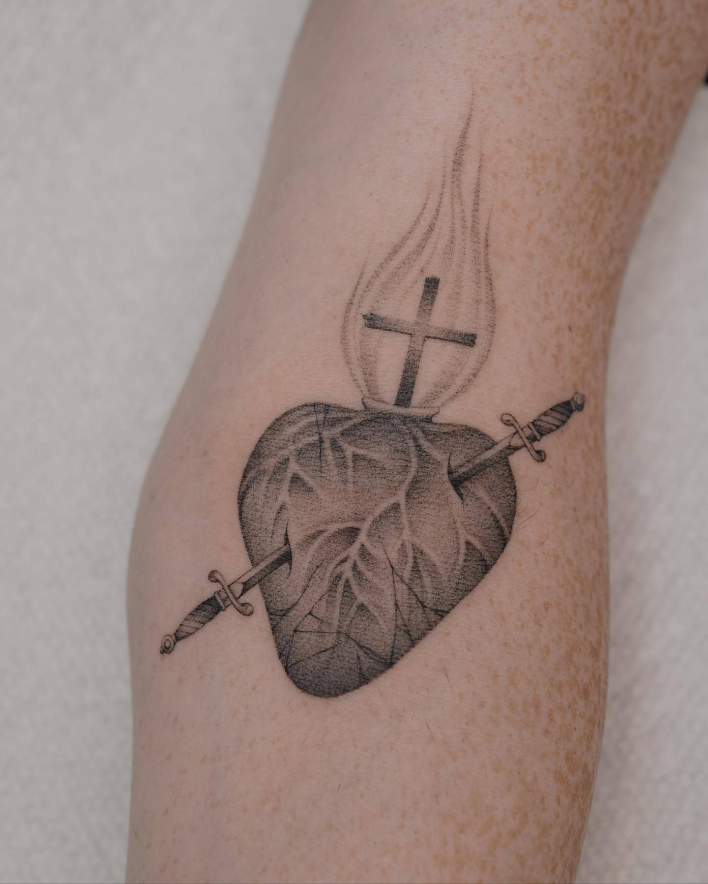 Heart with cross and sword realism tattoo on the forearm by Jason Lu ✪