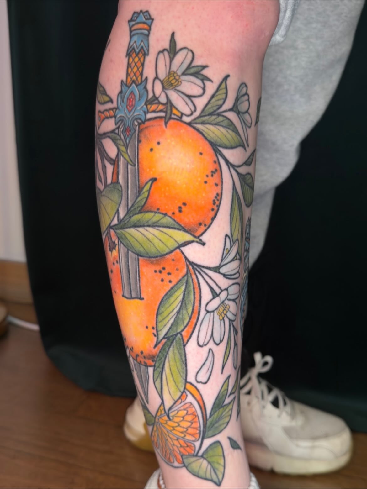 Orange and floral new school tattoo on the calf by Jessica Haug