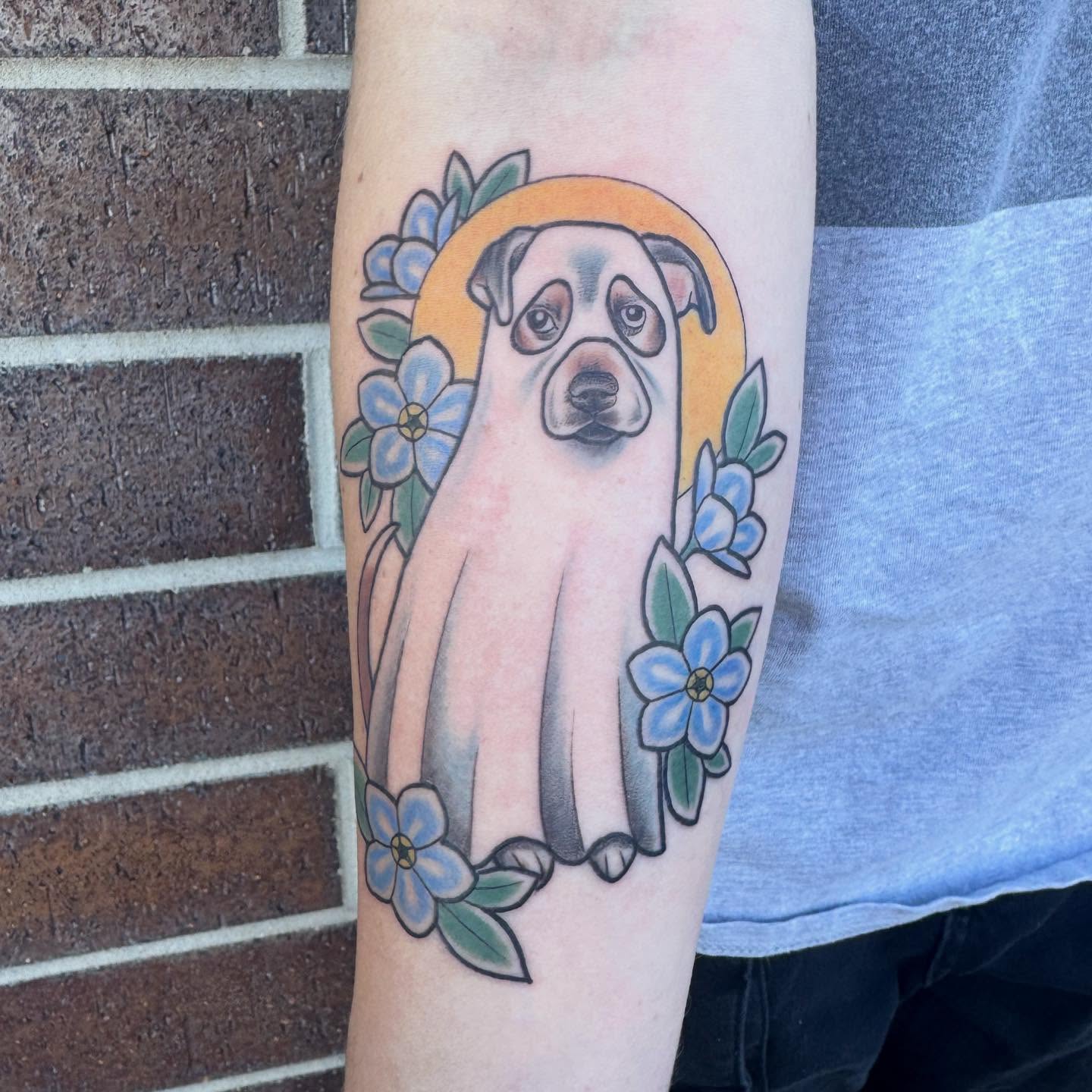 Dog with flowers American traditional tattoo on the forearm by Nikki Powills