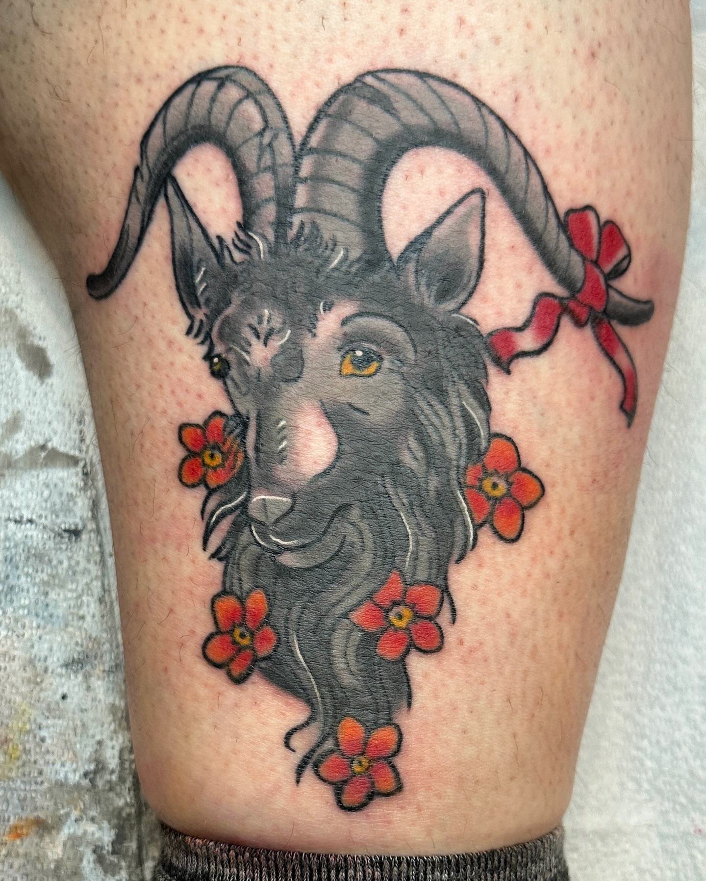 Ram head with flowers American traditional tattoo on the thigh by Paige Ochoa
