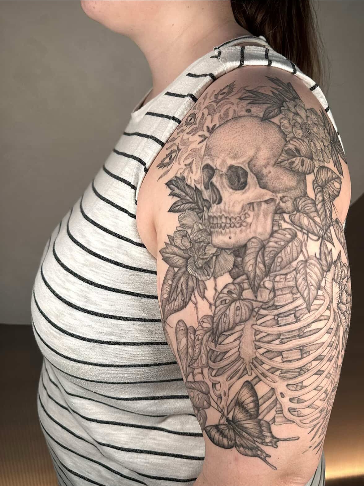 Skull and flowers realism tattoo on the shoulder by Carmen Figueroa, New York, New York