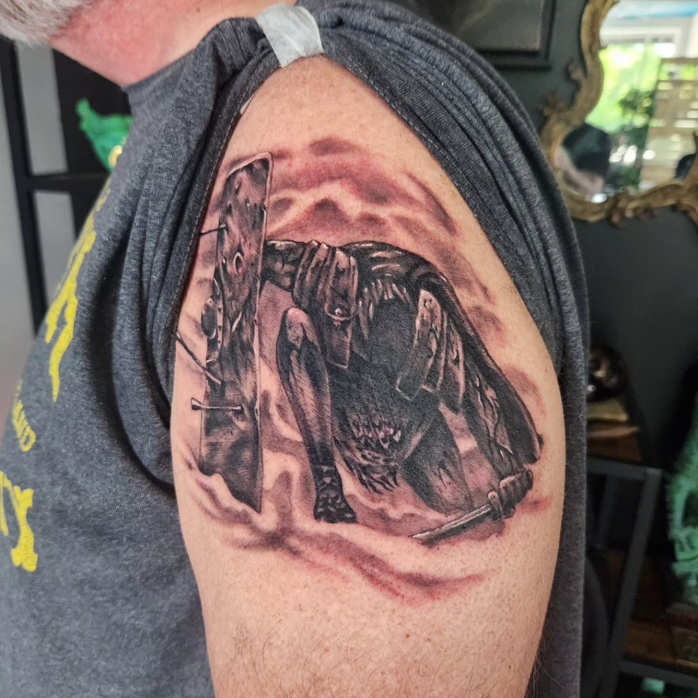 Kneeling warrior with shield and sword realism tattoo on the shoulder by Geo
