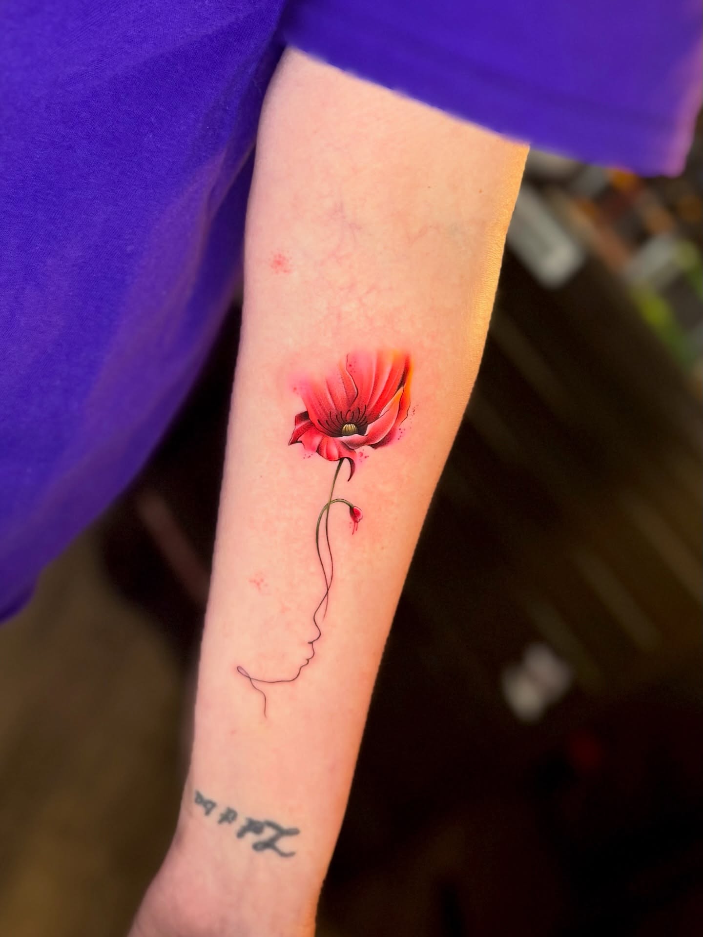 Poppy watercolor tattoo on the forearm by Franz Muñoz