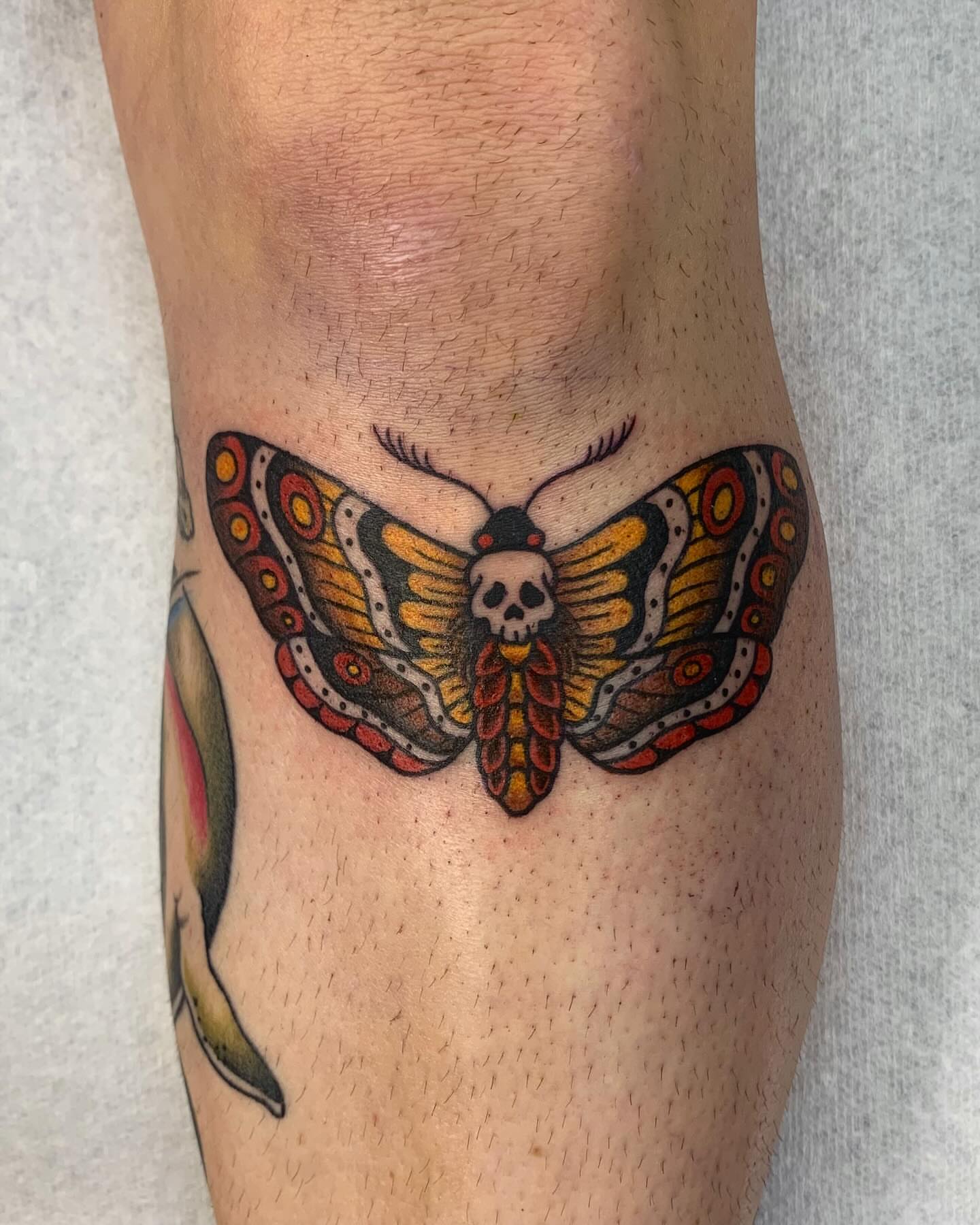 Butterfly with skull trash polka tattoo on the forearm by jay