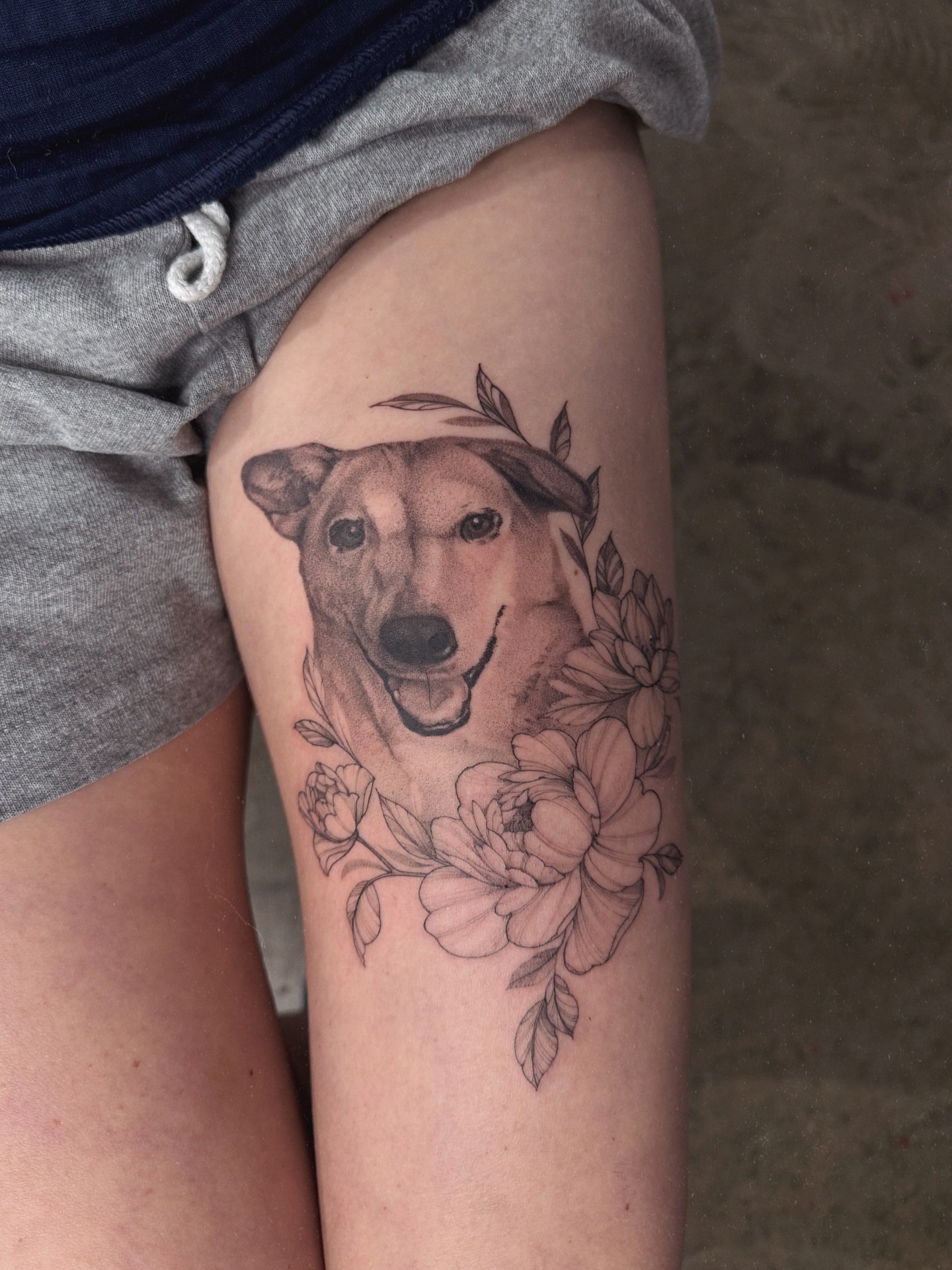 Dog with floral wreath realism tattoo on the thigh by Anastasiia Pakhanova ♥ tattoo artist