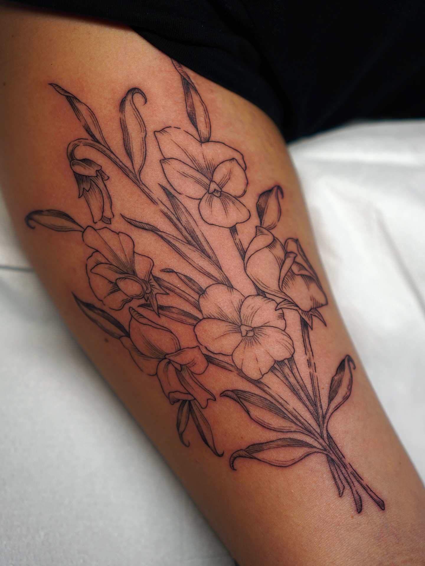 Flowers black and grey tattoo on the thigh by Carlos Abad