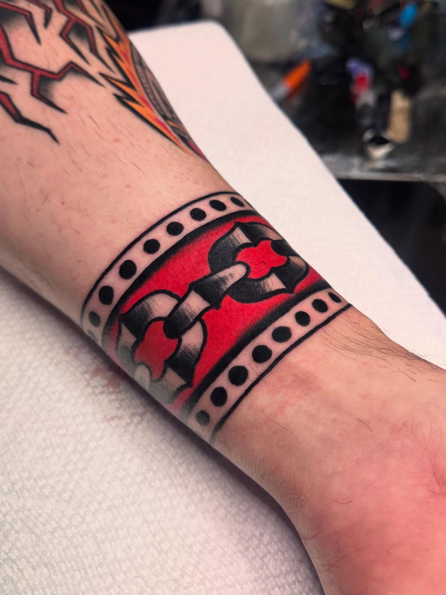 Film strip American traditional tattoo on the forearm by Ryan Engels